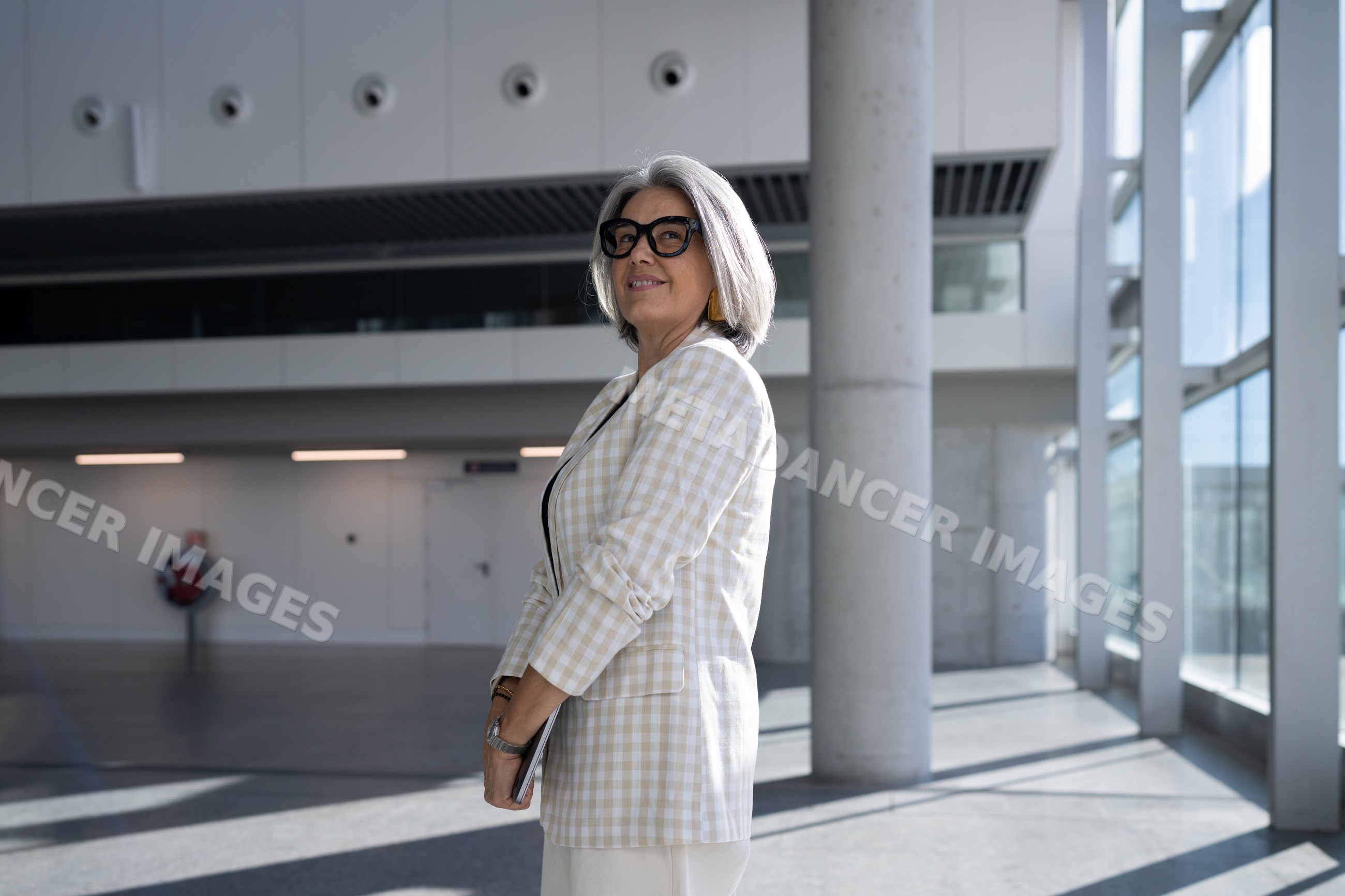 Businesswoman standing in modern office building holding tablet