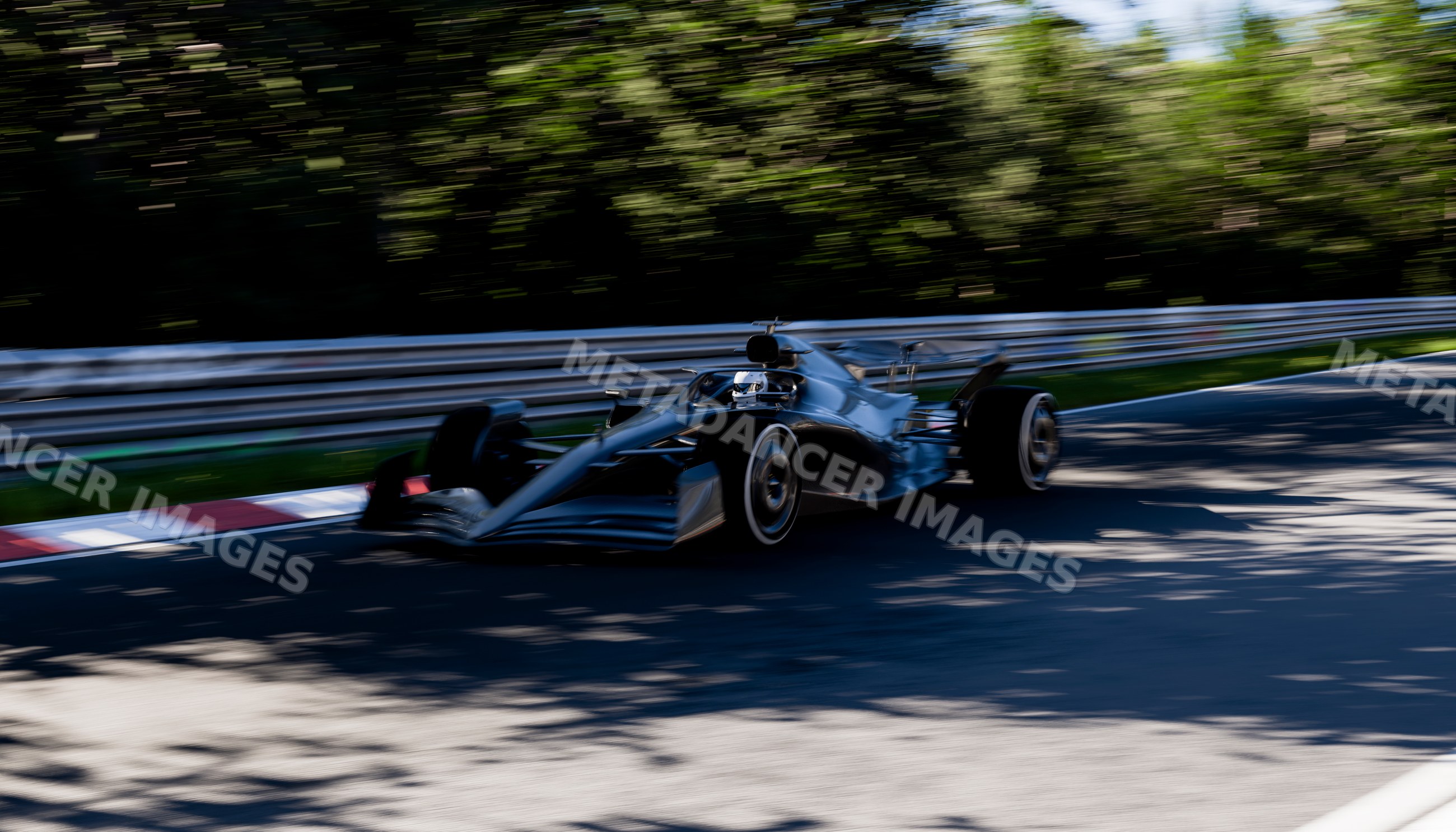 Black racecar speeding around a corner on a race track