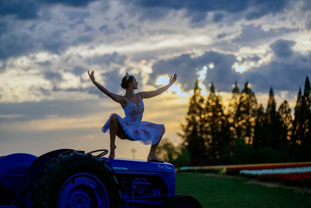Ballet white dancer performing atop blue tractor