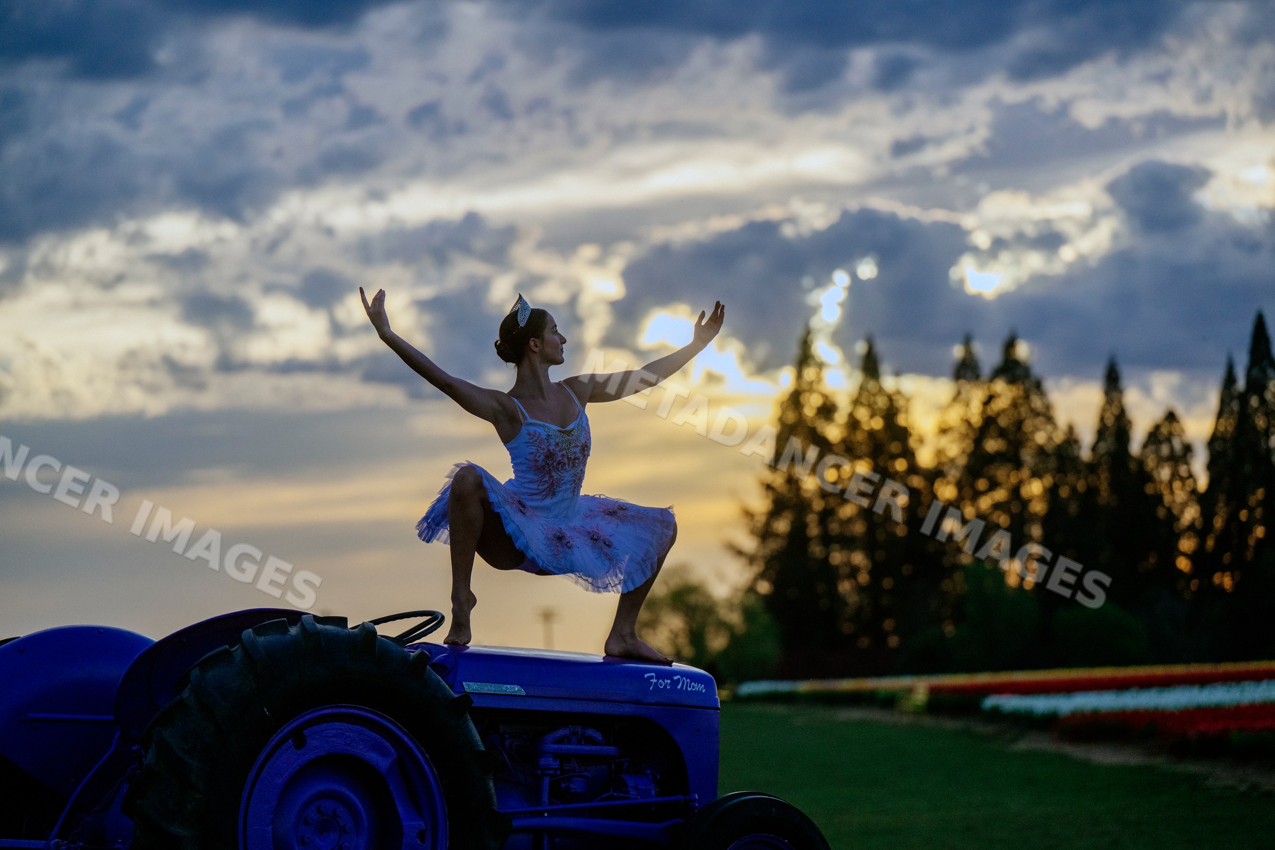 Ballet white dancer performing atop blue tractor