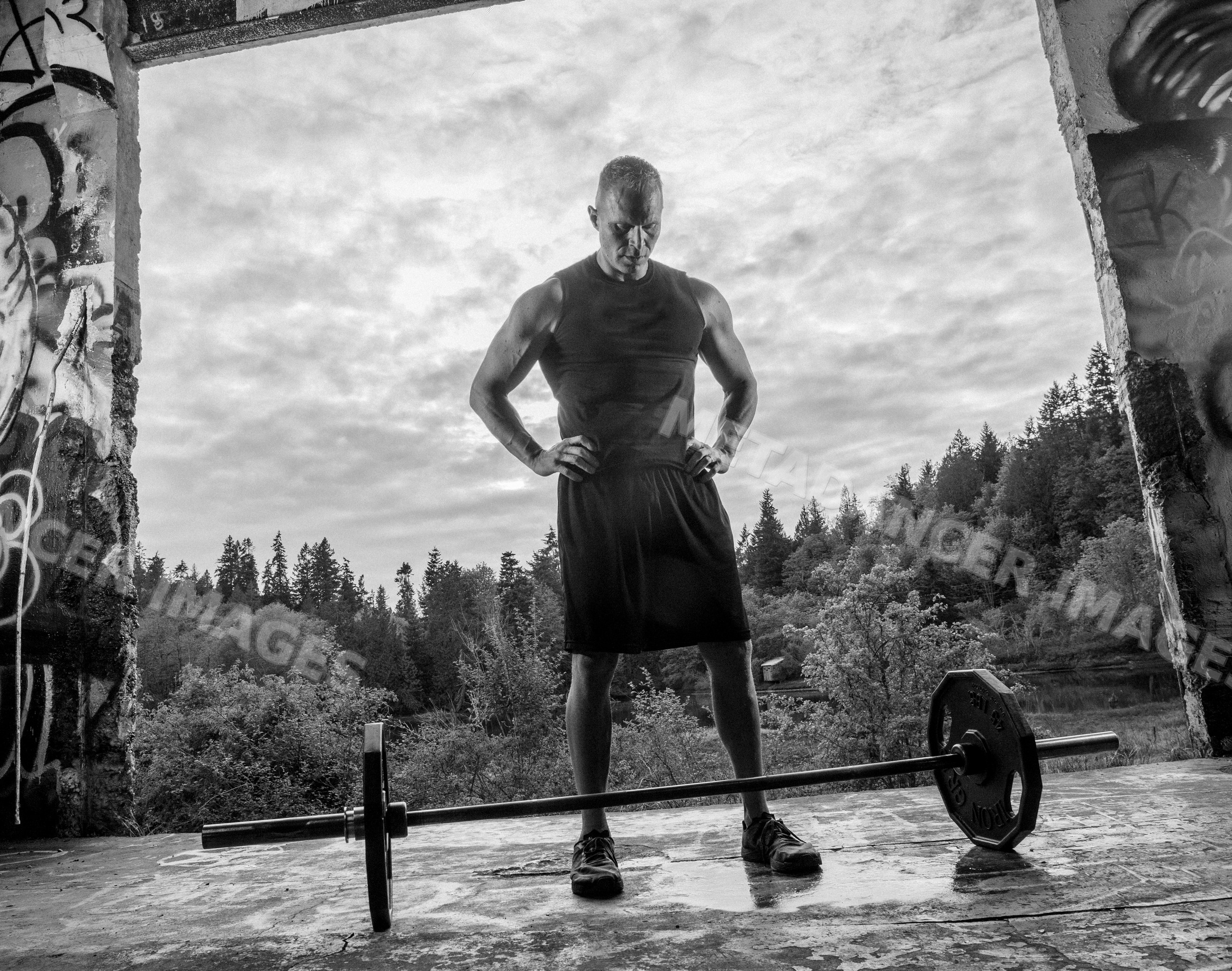 Muscular white man preparing to lift barbell during outdoor workout
