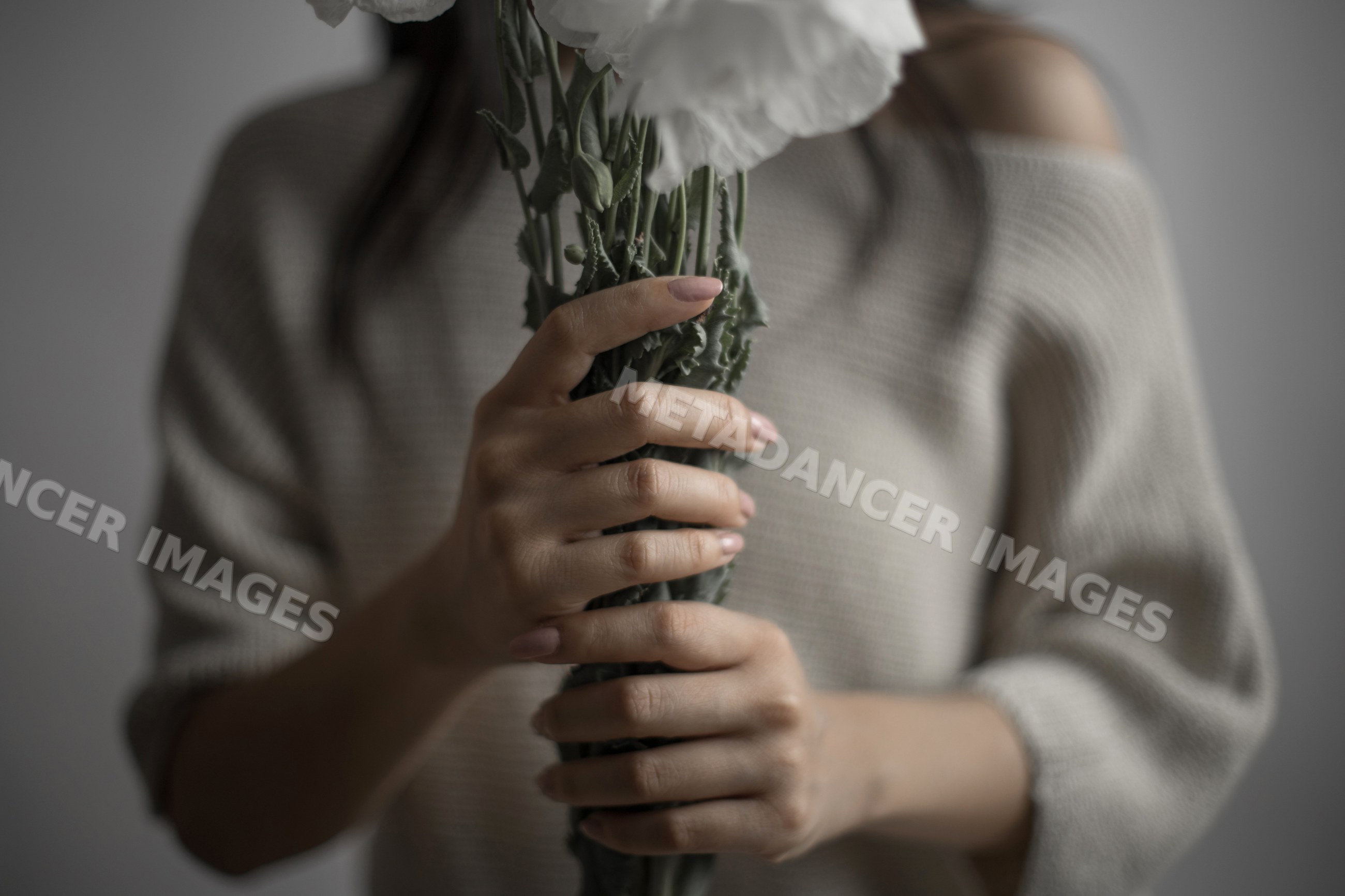 Southeast Asian woman holding white carnations bouquet