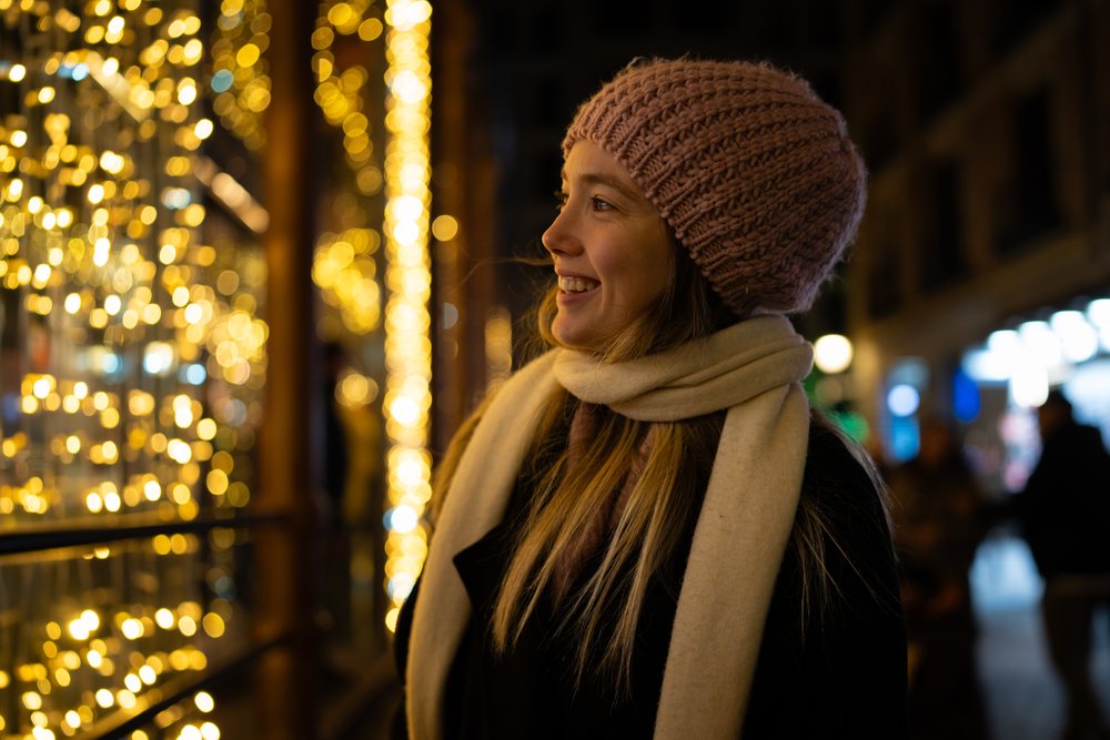 White woman enjoying christmas market holiday lights