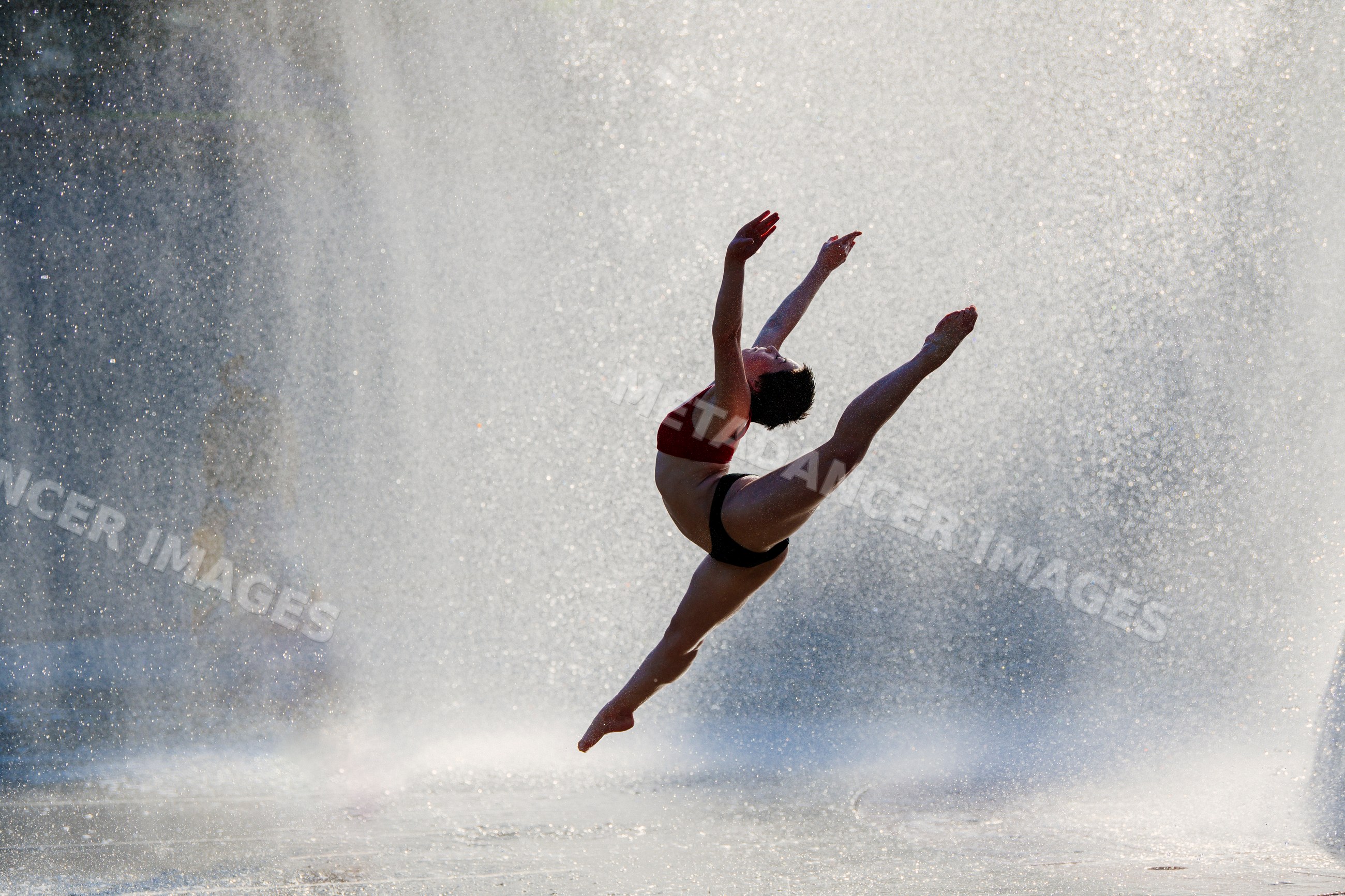 White dancer leaping through water spray