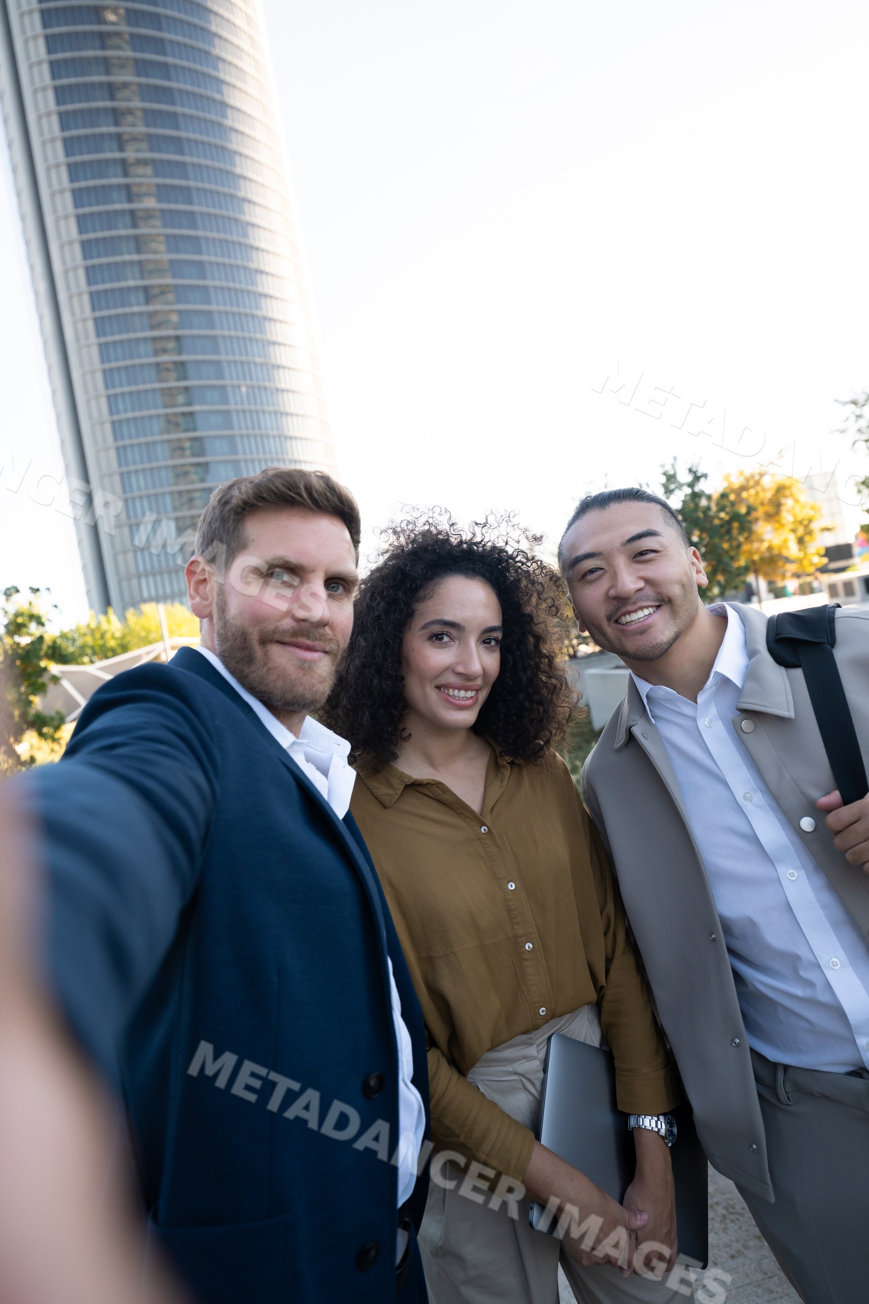 Three business white professionals taking selfie outdoors in city
