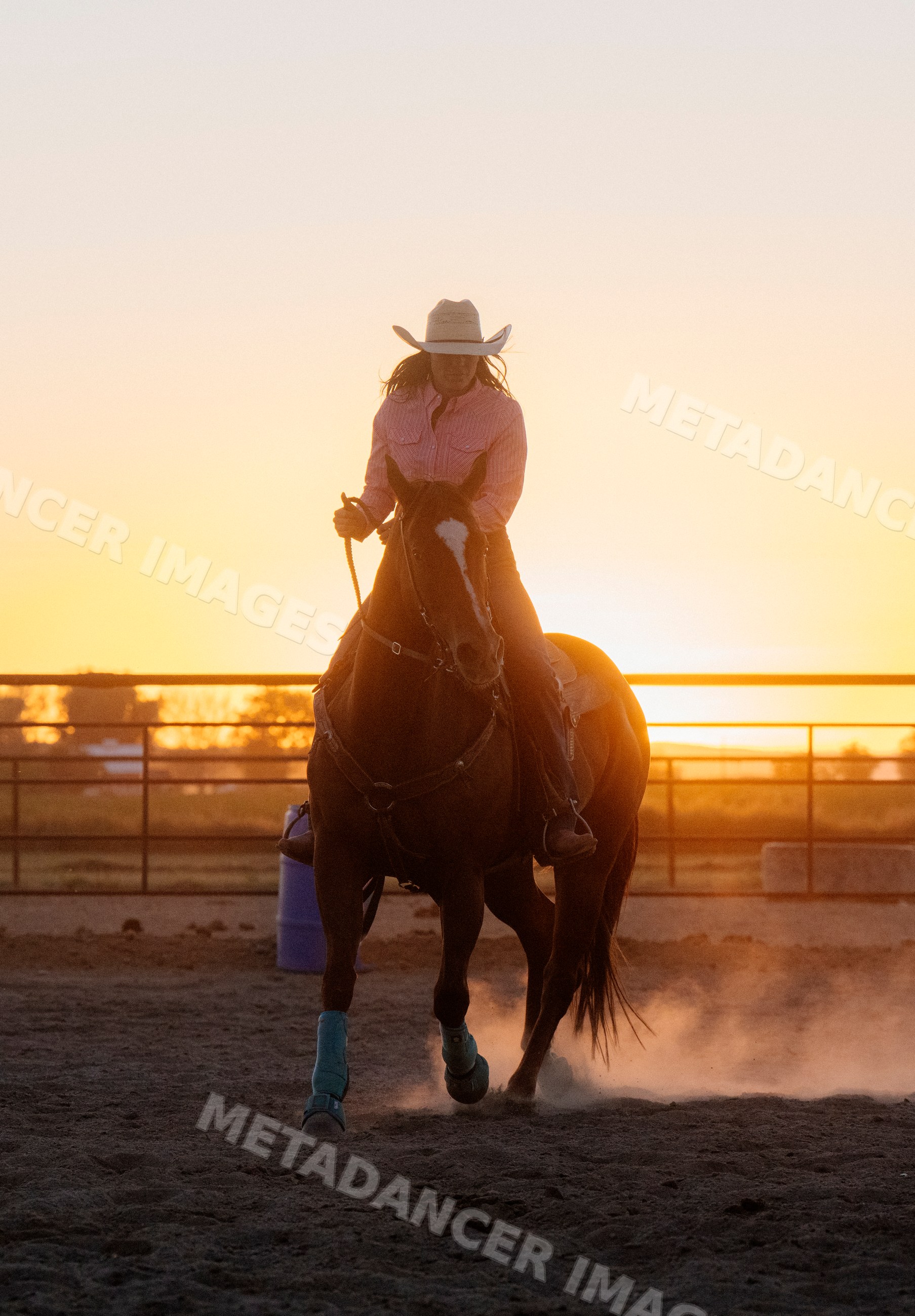 Horseback riding at sunset in an outdoor arena