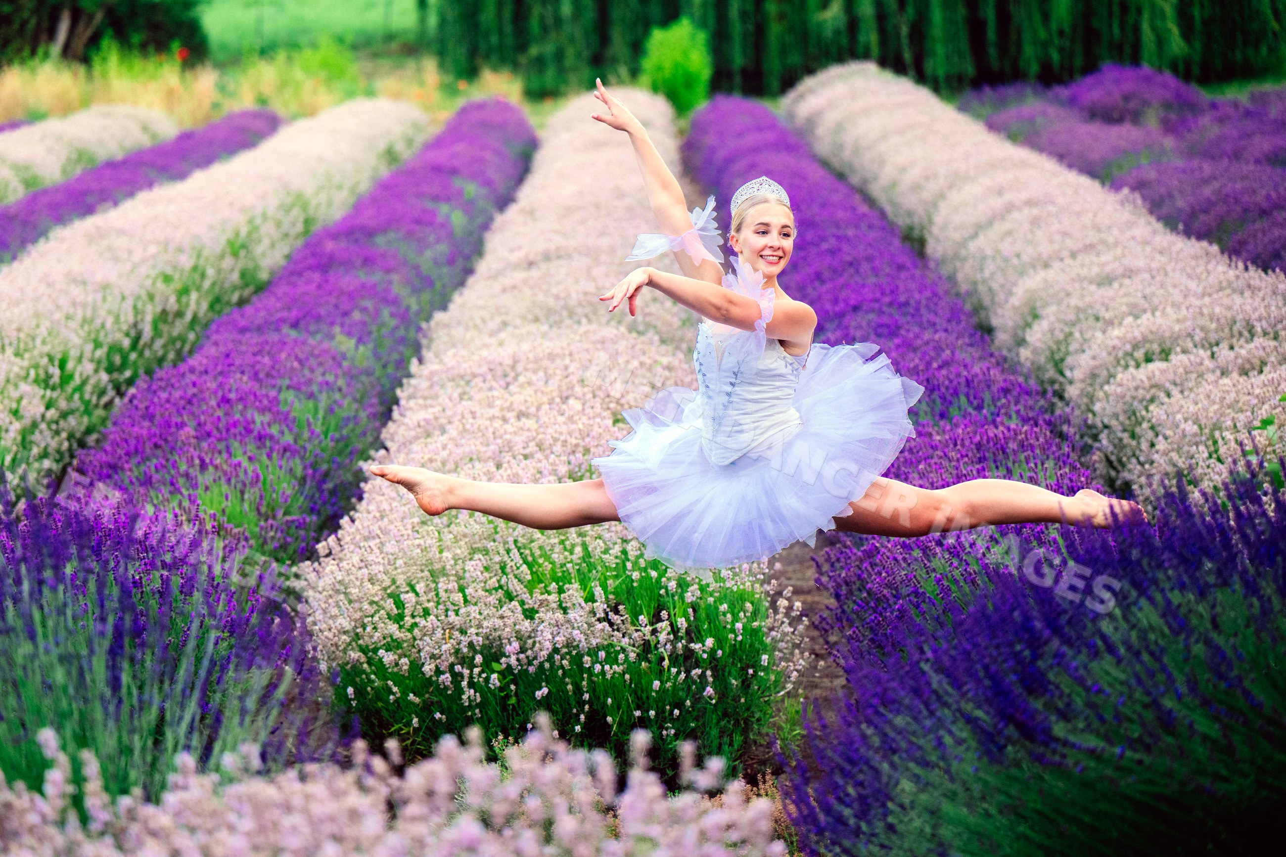 A ballet white dancer leaps gracefully outdoors