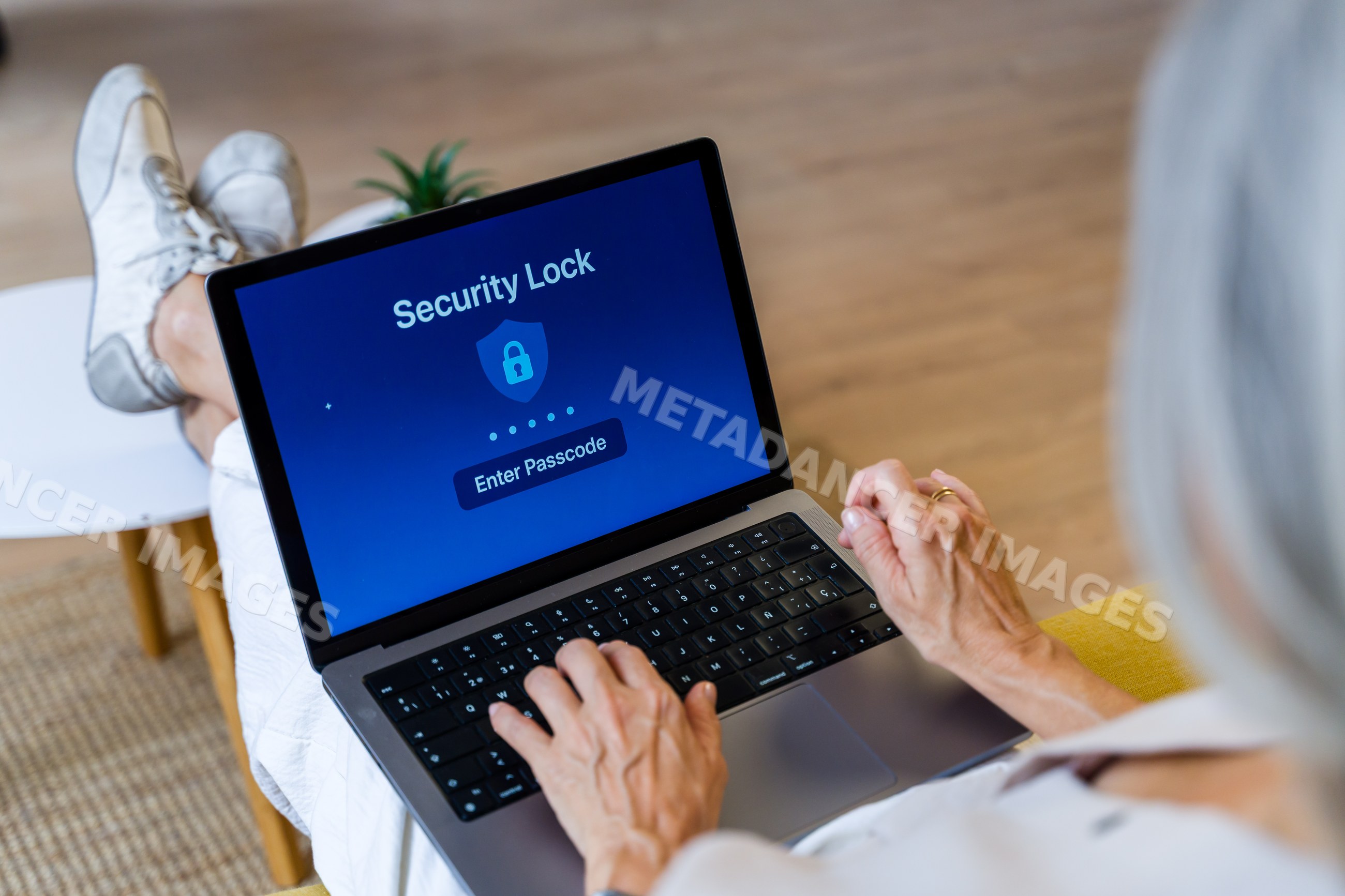 Senior white person entering passcode on laptop security lock screen