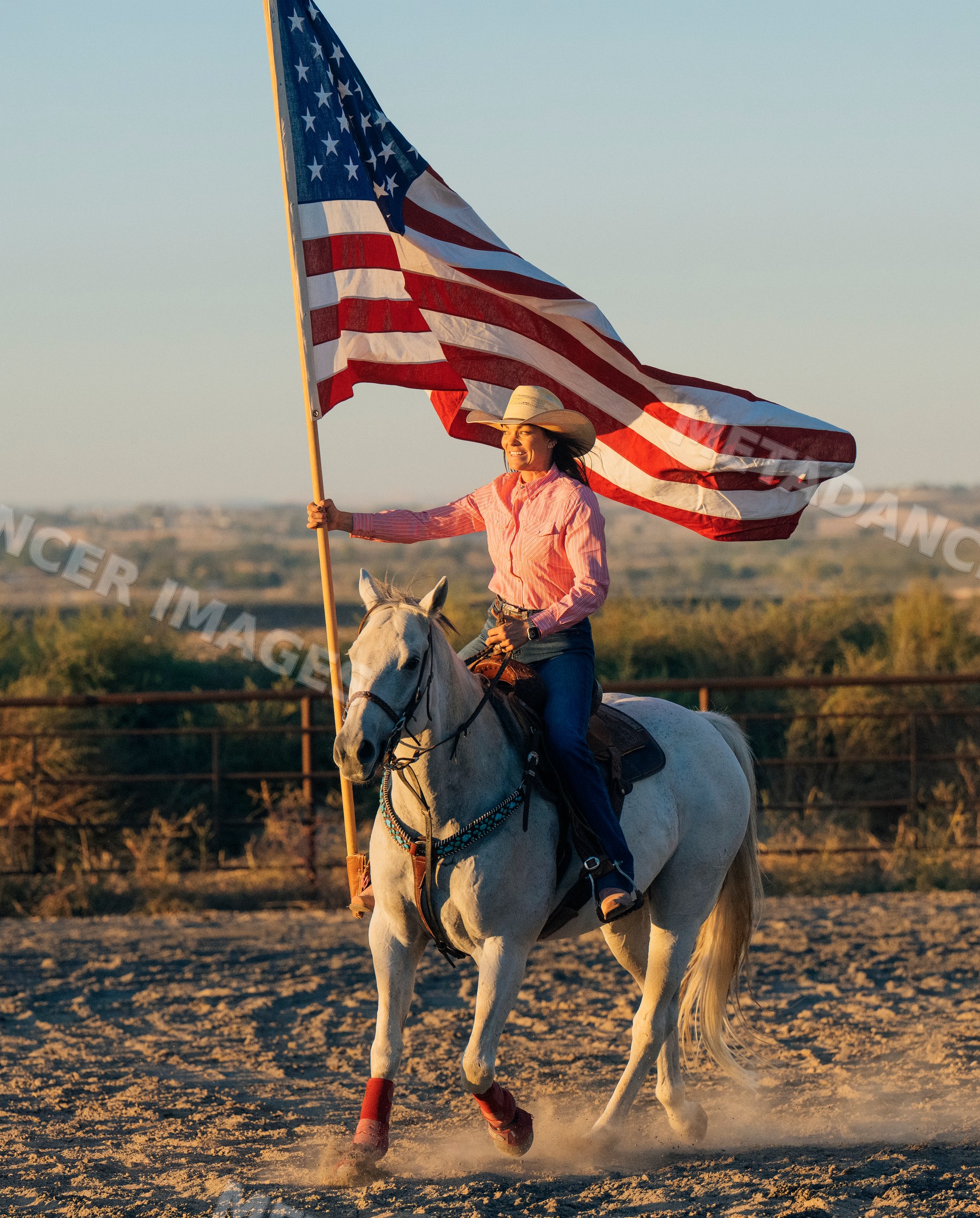 White woman riding horse holding american flag