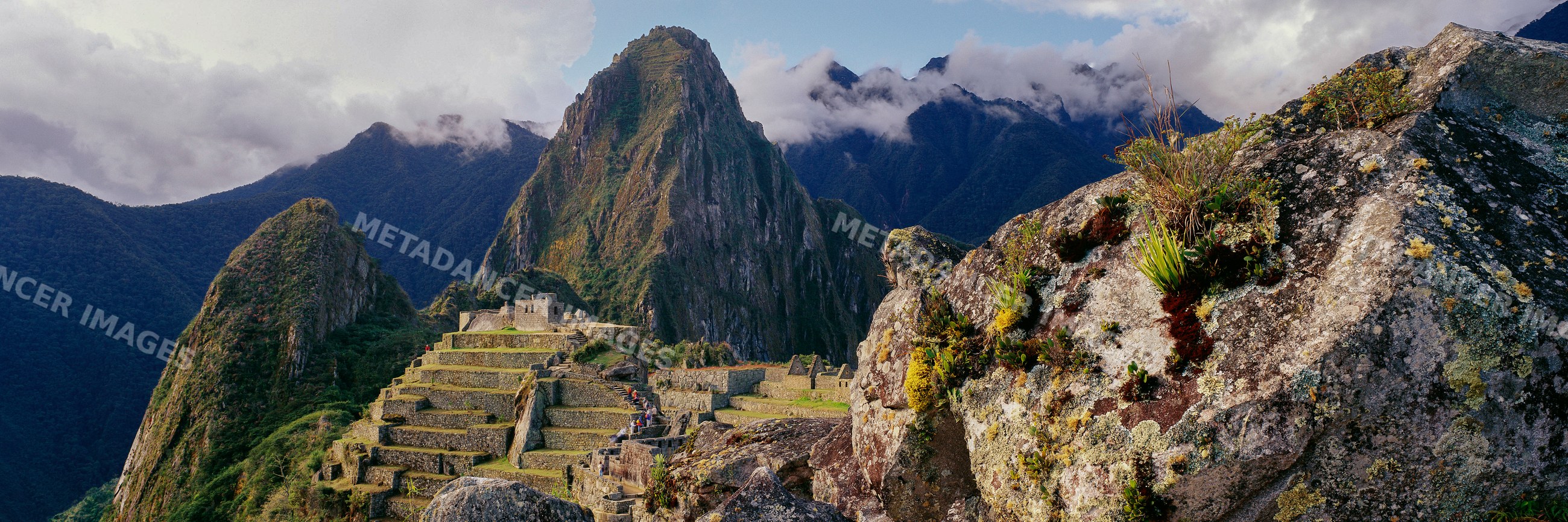 Ruins of machu picchu terraces with mountains and clouds in peru