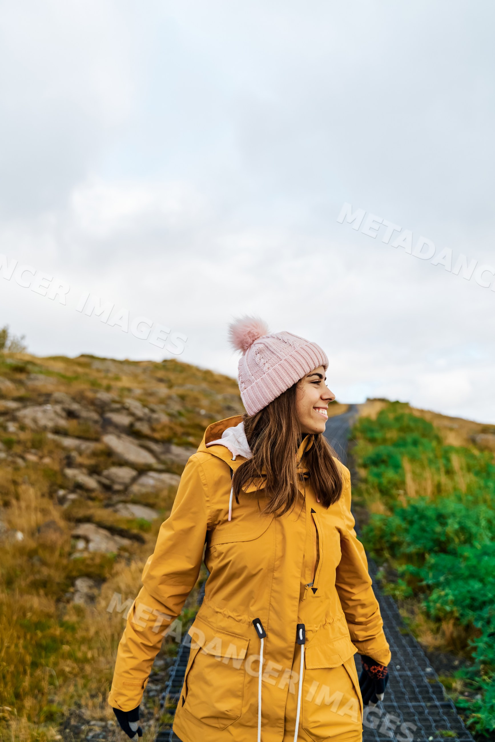 White Woman smiling and walking outdoors on a rocky path