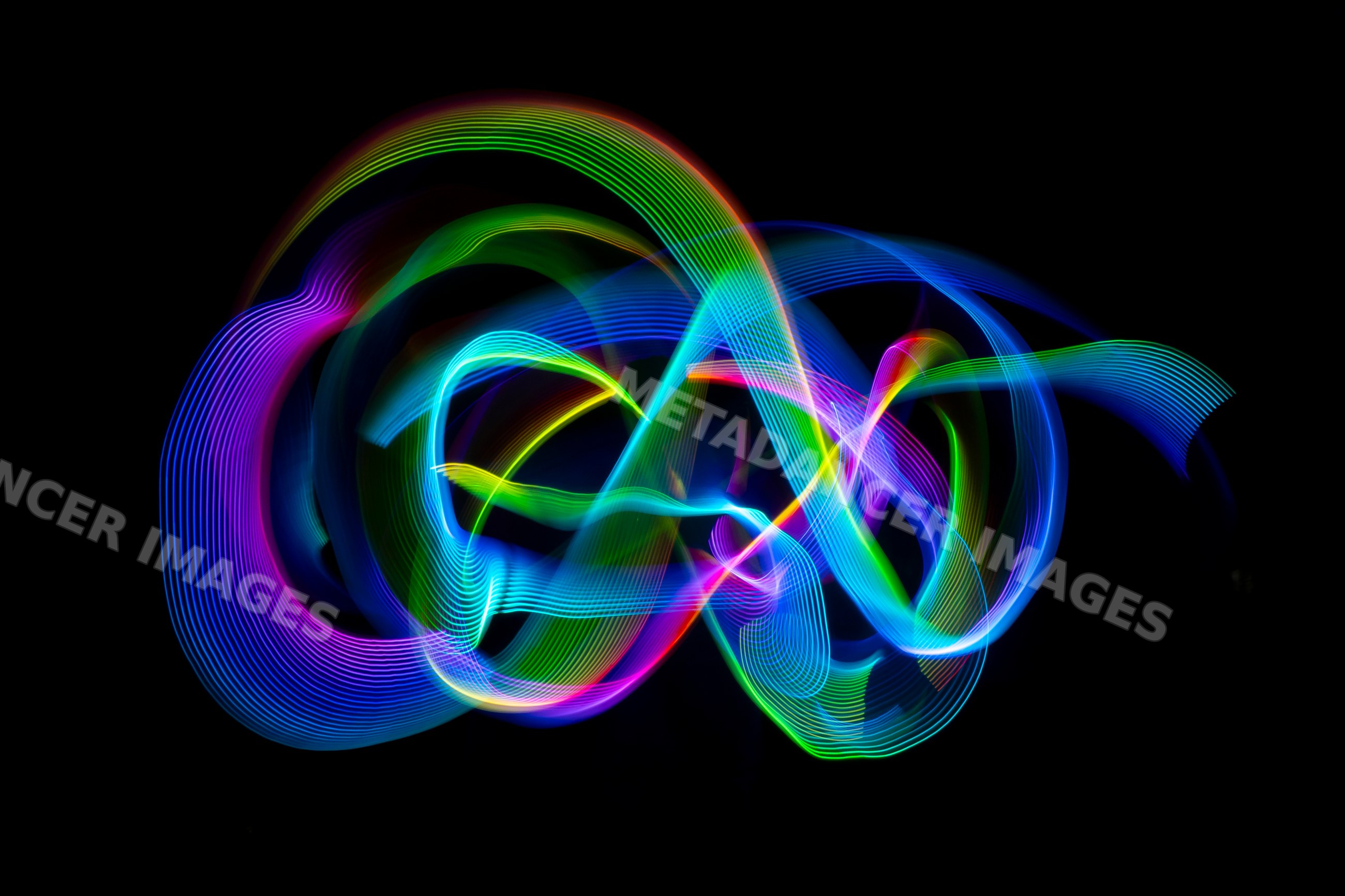 Colorful light painting creating swirling trails on dark background