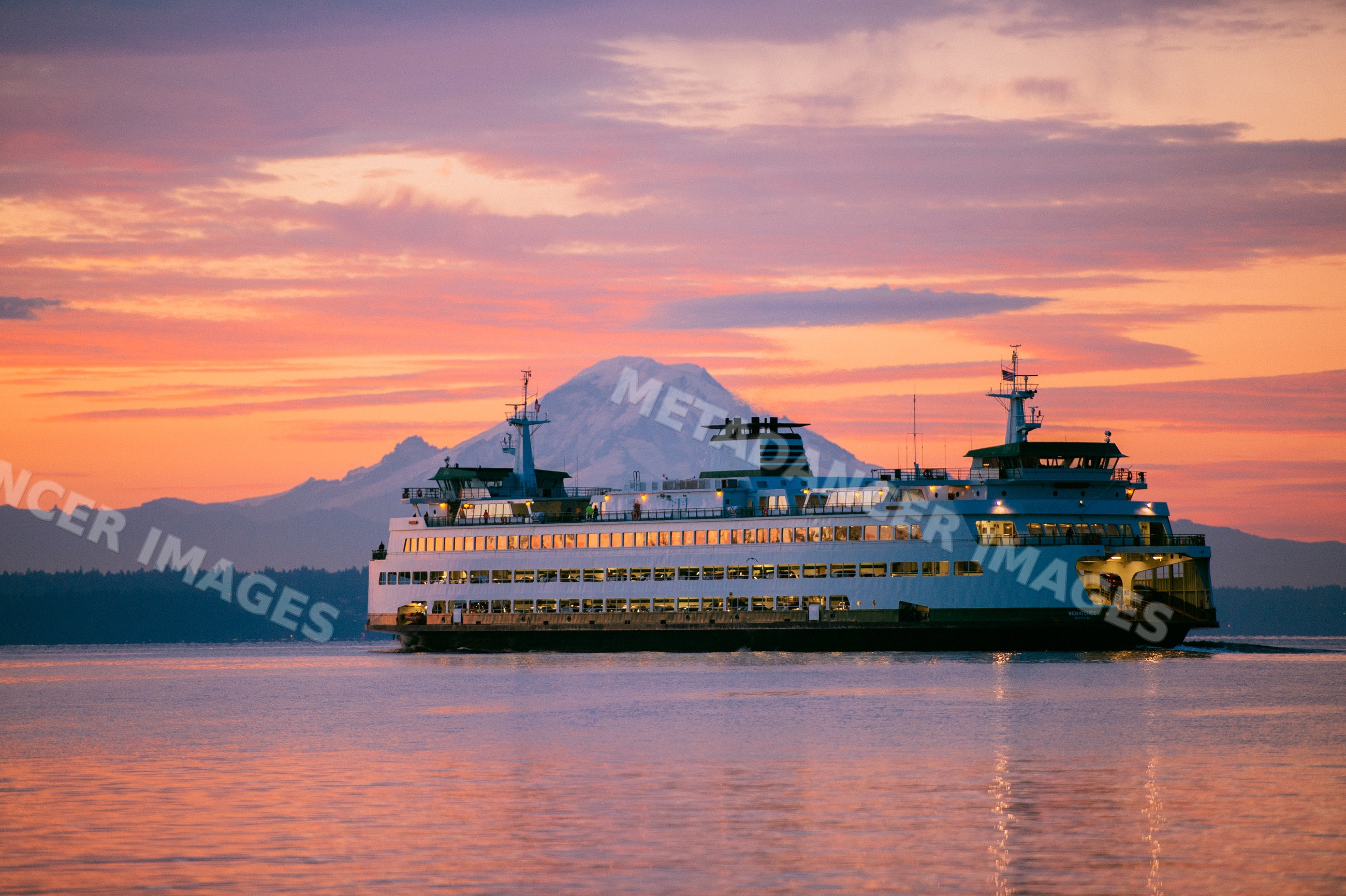 Ferry sailing at sunset with mount rainier in the background