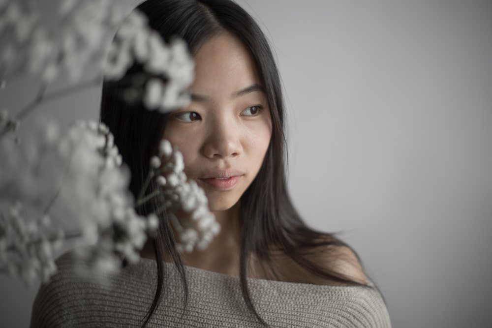 Emotional portrait of young asian Southeast Asian woman with flowers
