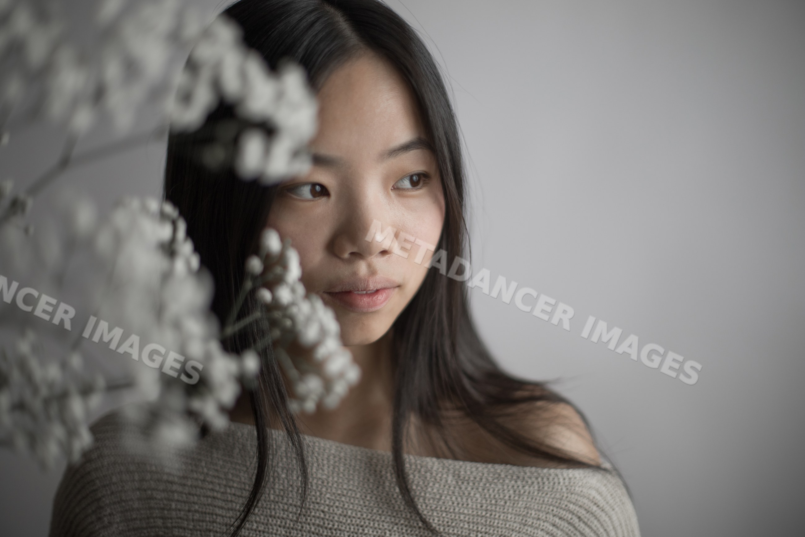 Emotional portrait of young asian Southeast Asian woman with flowers