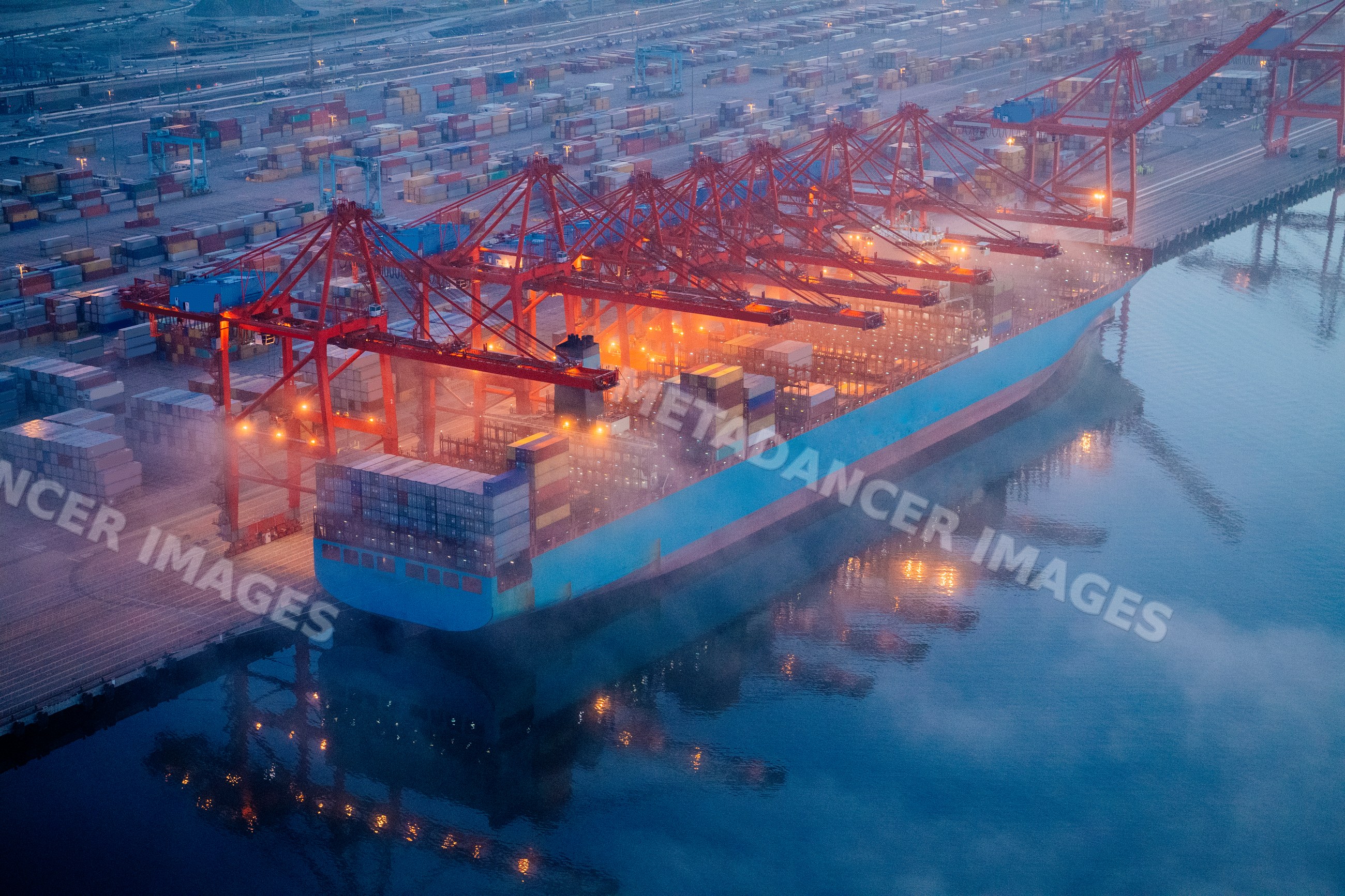 Container ship loaded with containers at port terminal in a beach