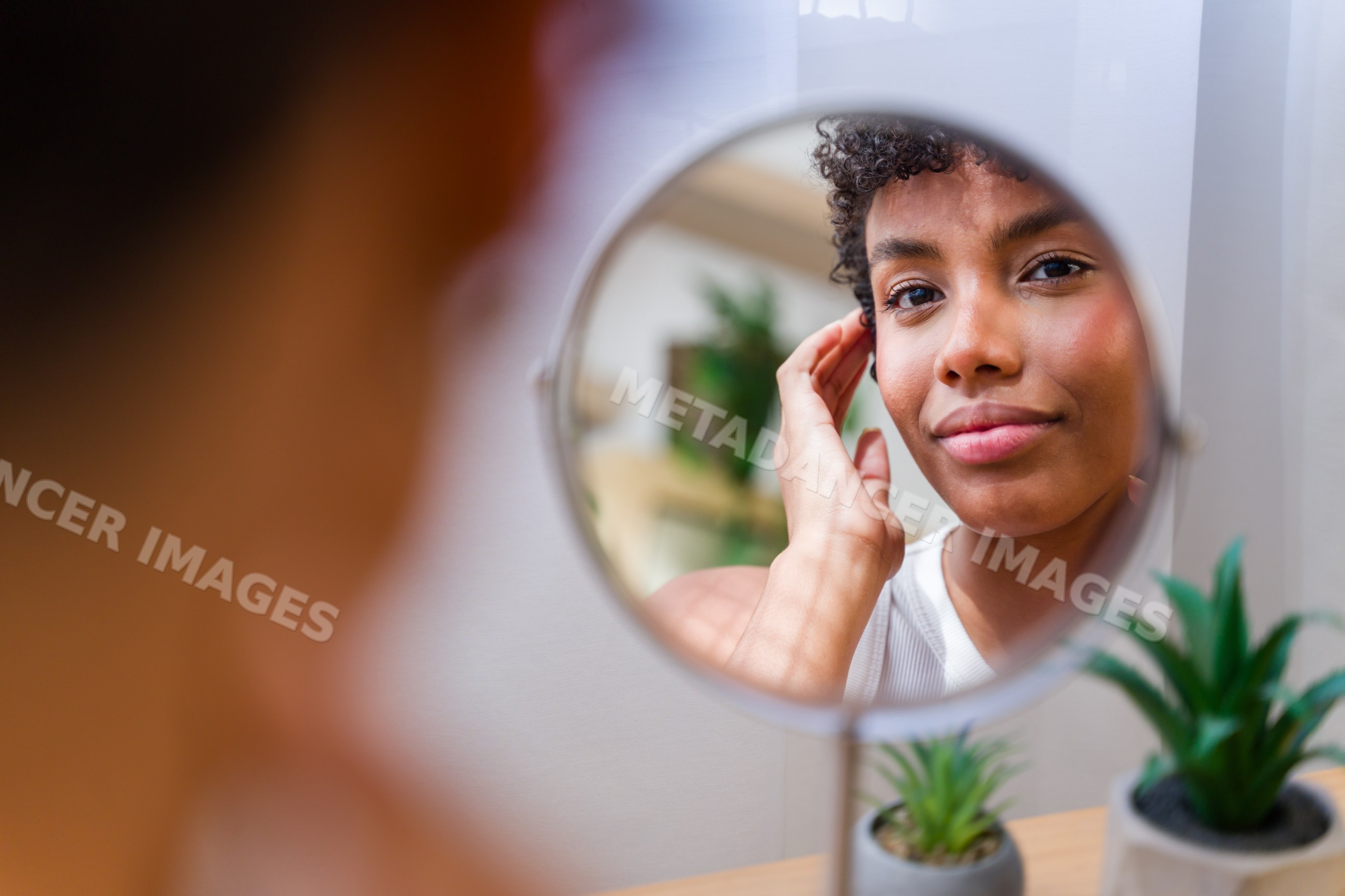 African American woman examining her face