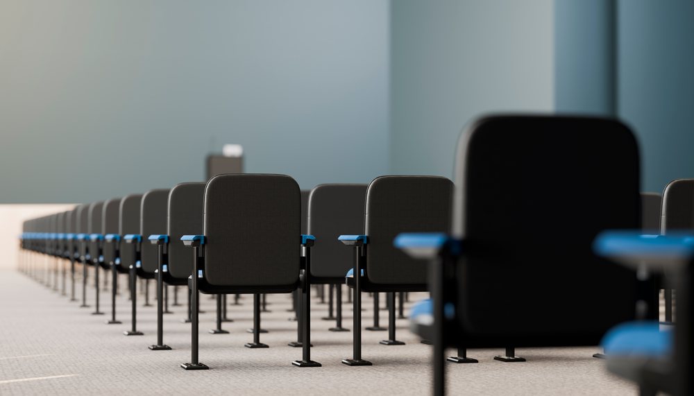 Rows of black chairs with blue armrests in a conference room