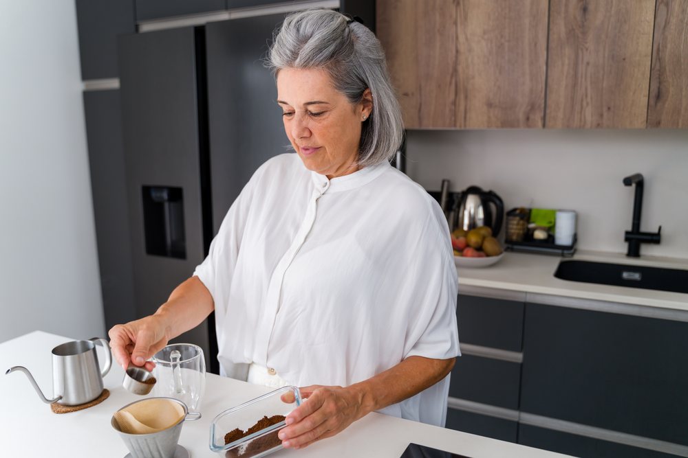 White Woman preparing pour over coffee in modern kitchen in Spain