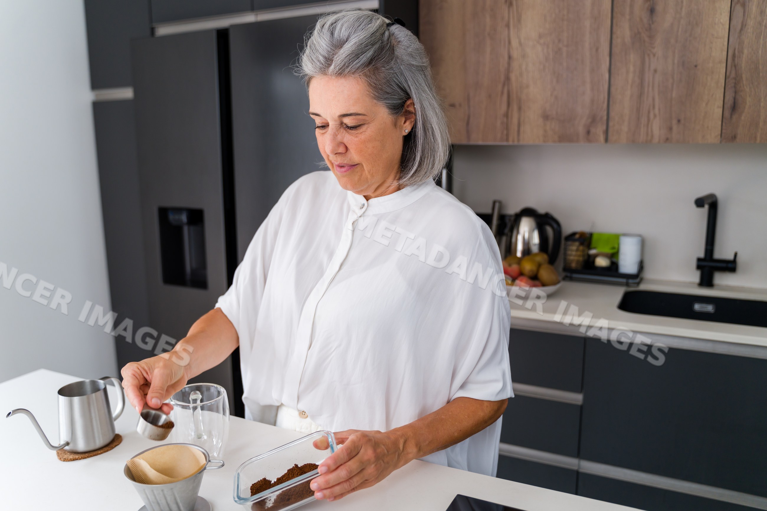 White Woman preparing pour over coffee in modern kitchen in Spain