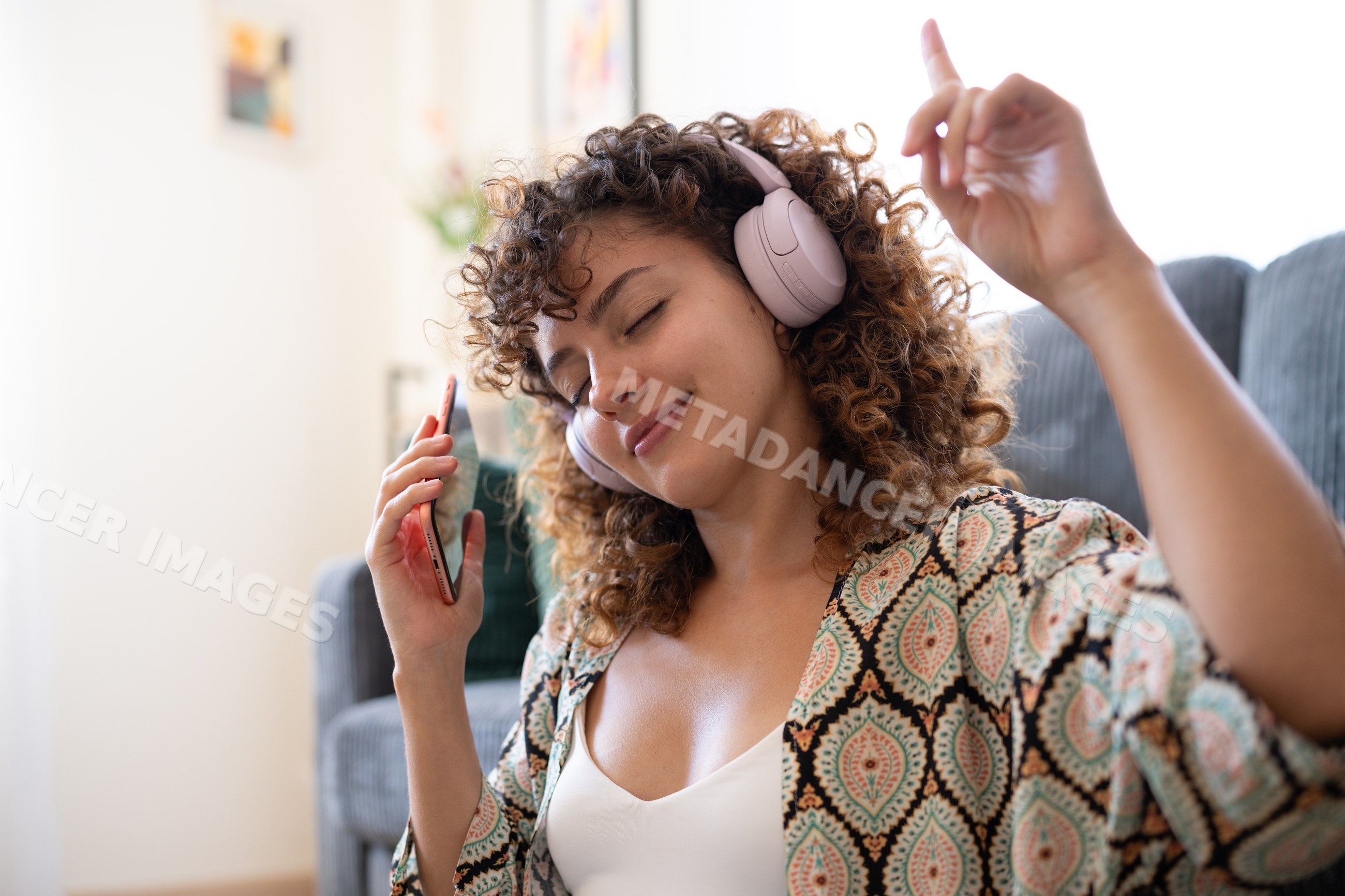 White woman relaxing at home in Spain enjoying music with headphones