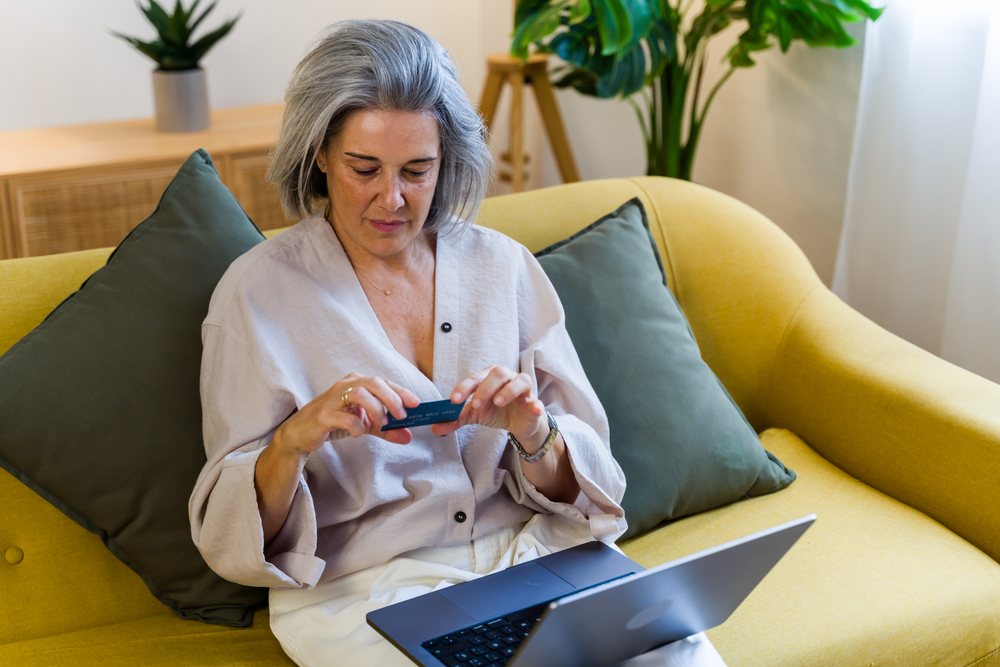 White woman using credit card and laptop for online shopping at home