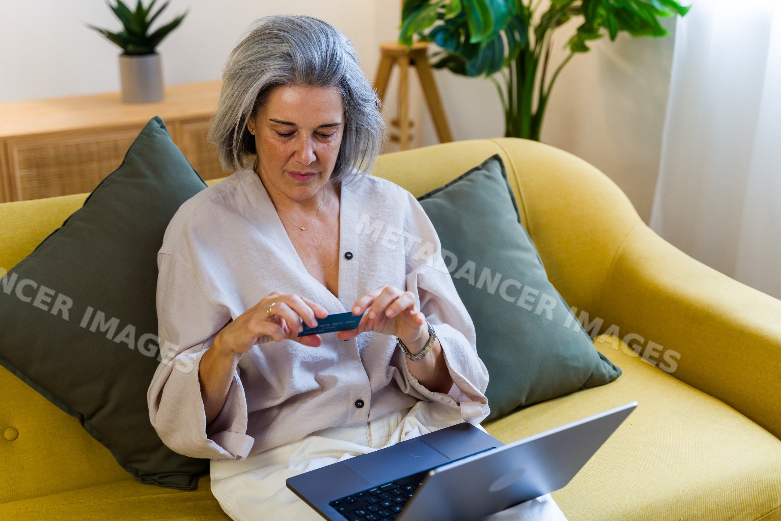White woman using credit card and laptop for online shopping at home
