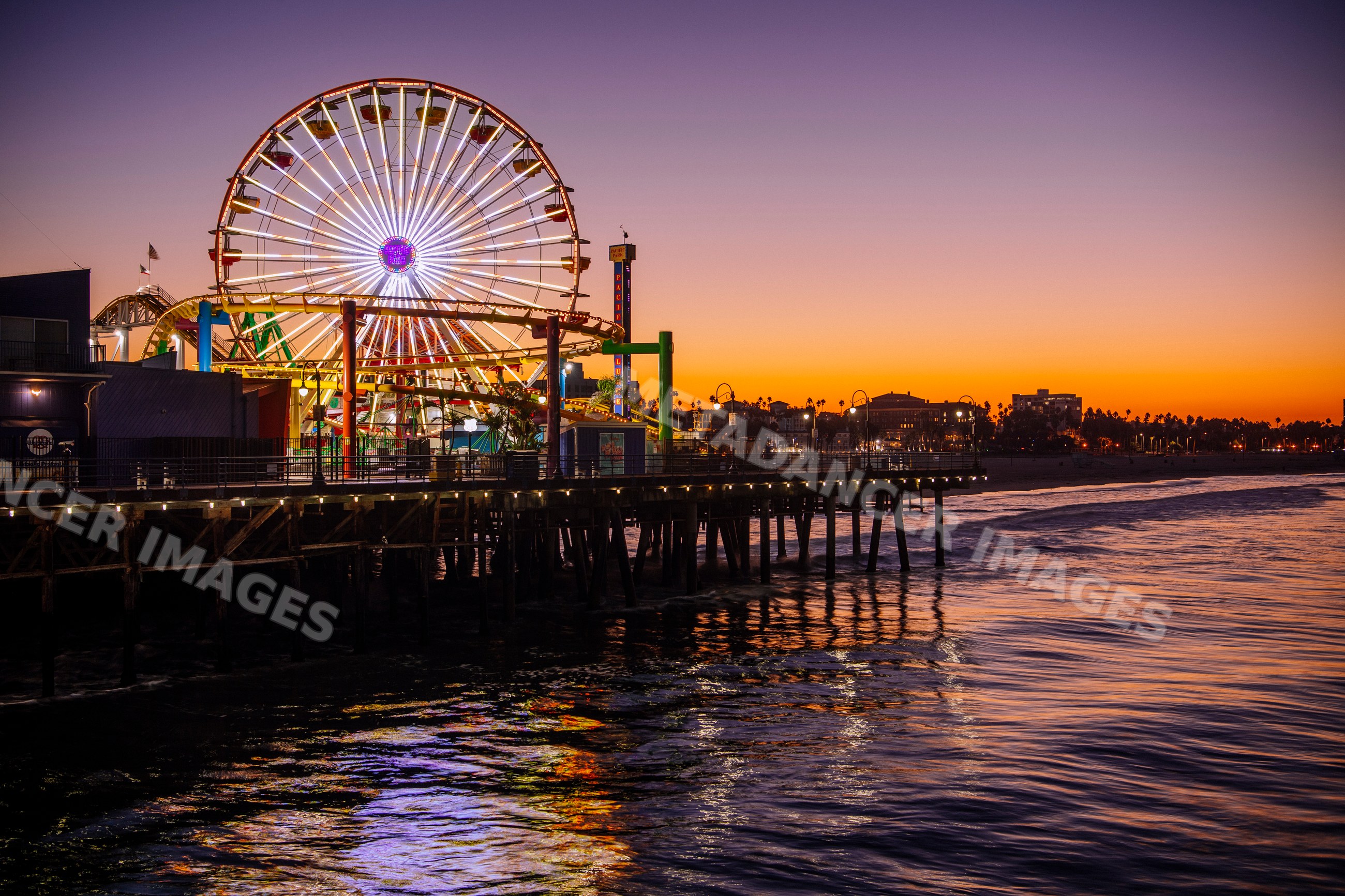 Santa Monica pier ferris wheel illuminated at sunset