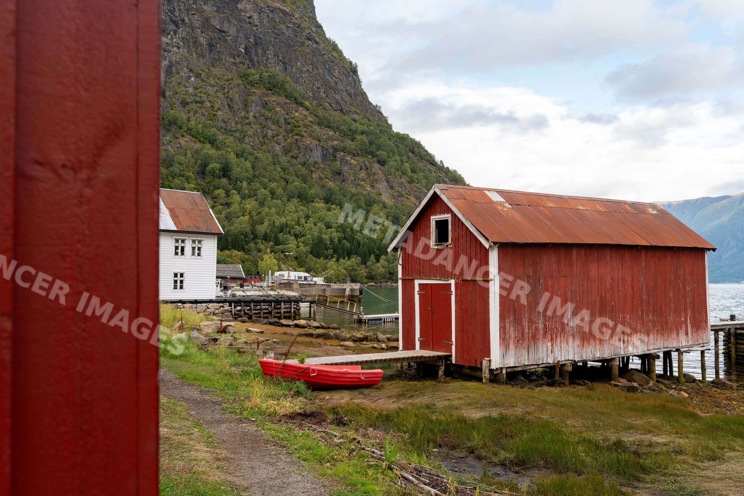Red wooden boathouse with dock on Luster Fjord, Norway