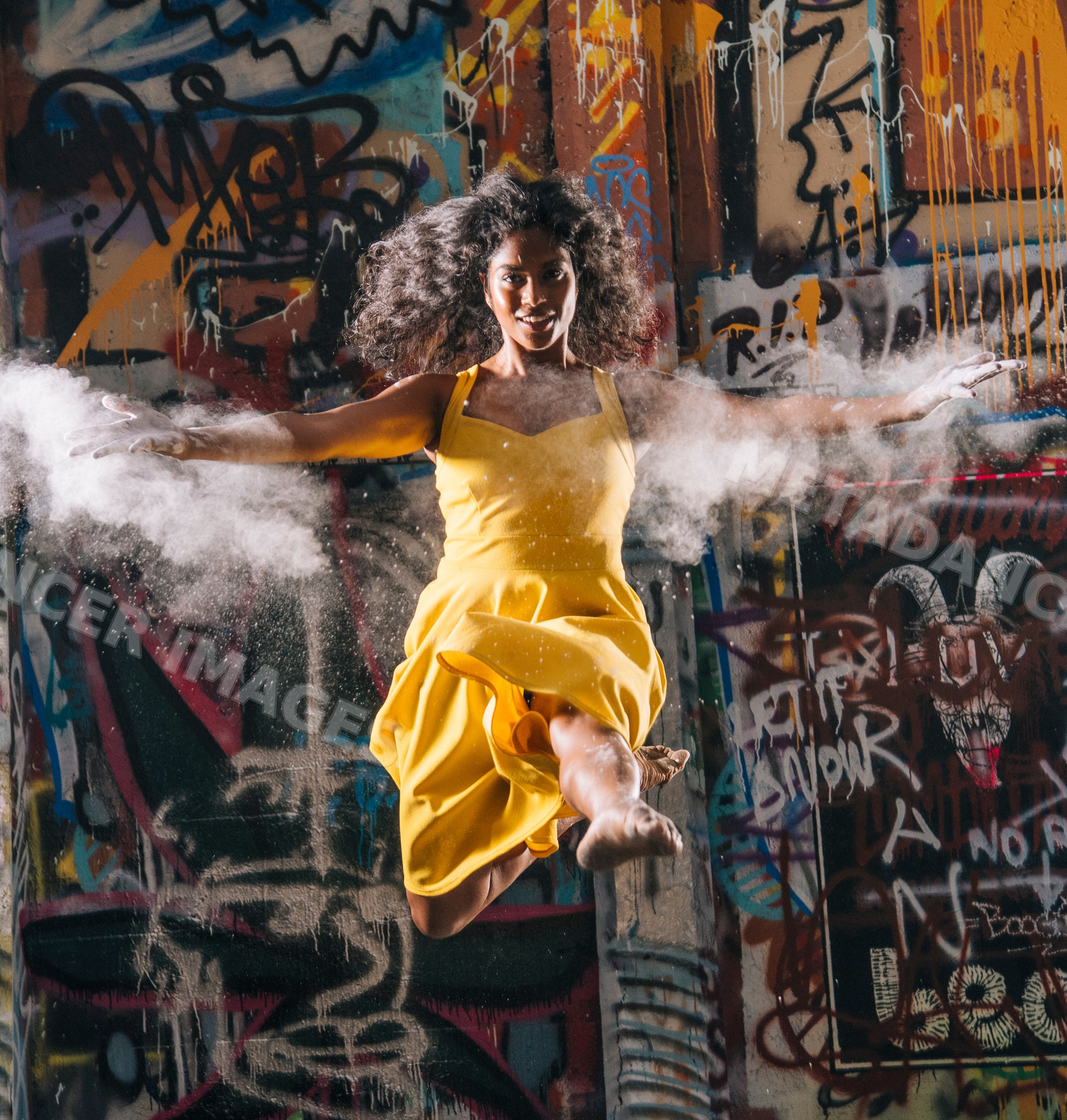 South Asian woman jumping with powder burst