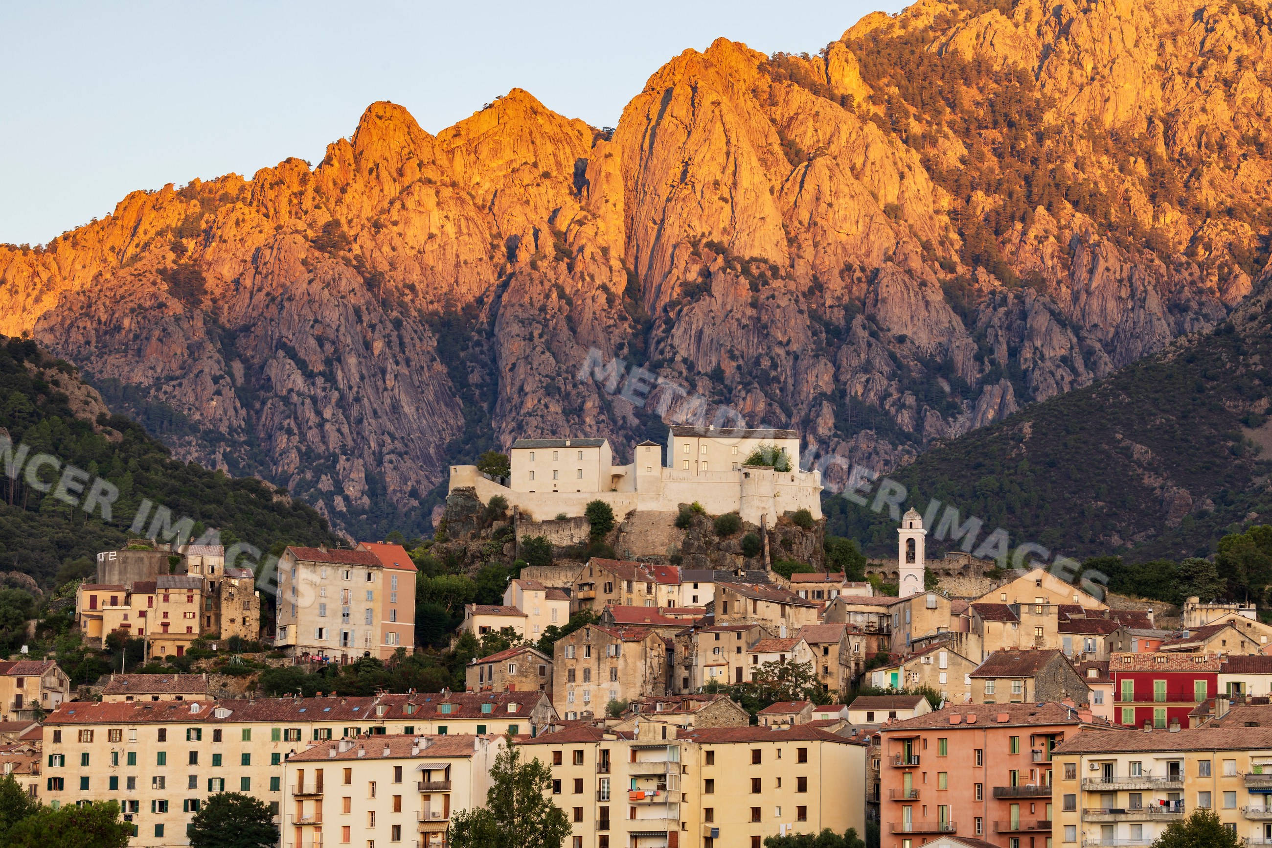 Sunrise illuminating mountains and fortress in Corte, corsica