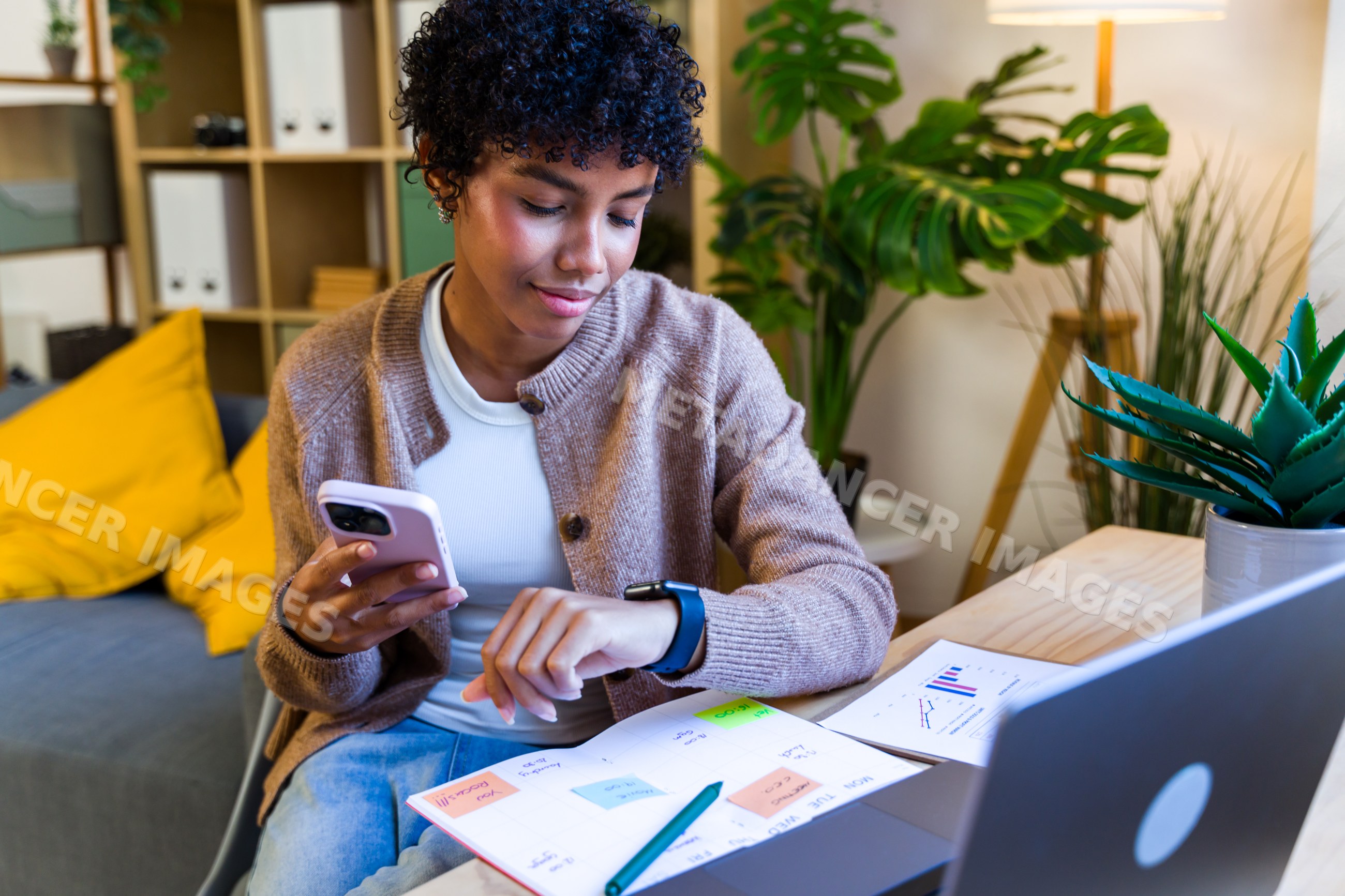 African American woman checking smartwatch and planning