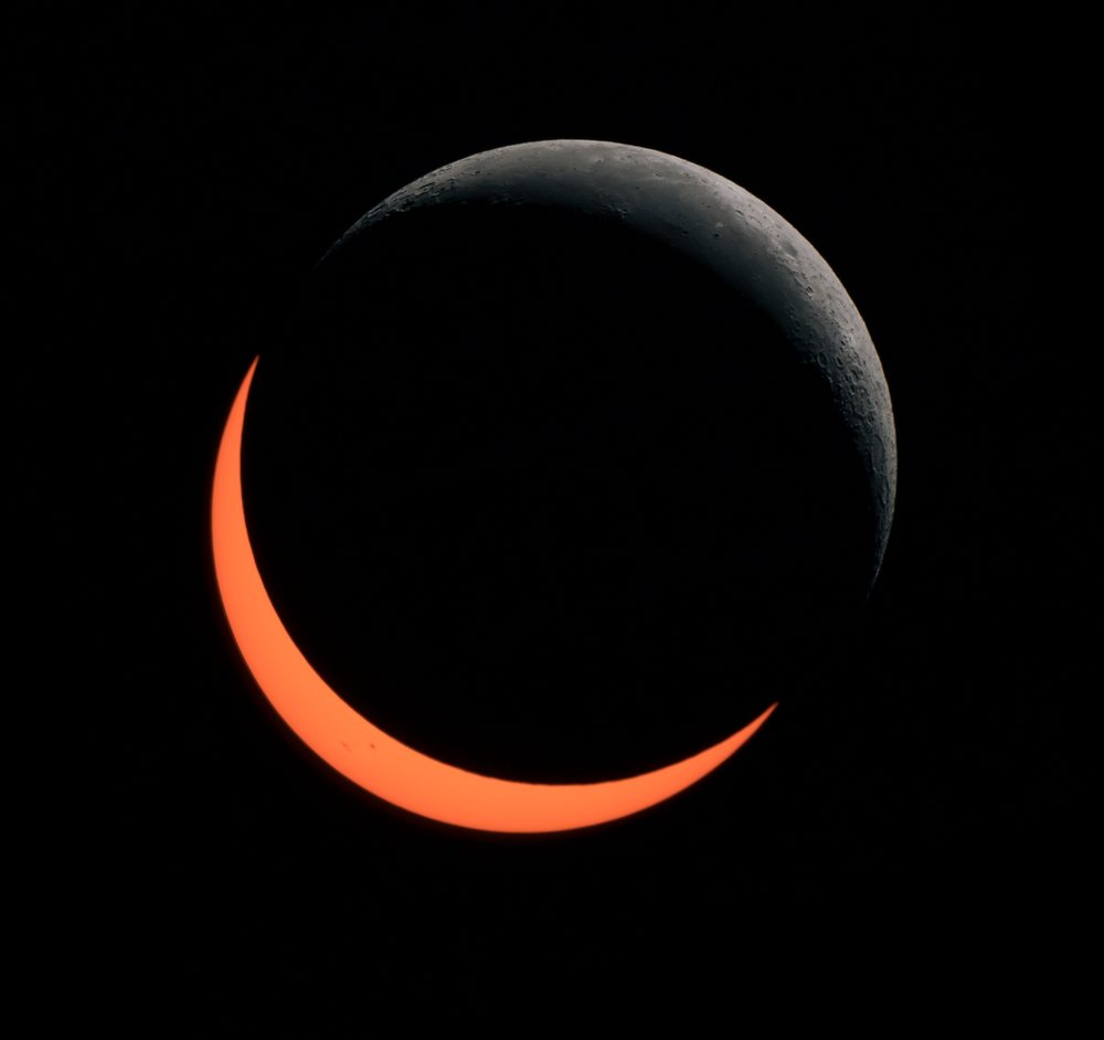 Partial solar eclipse with visible crescent moon and sun