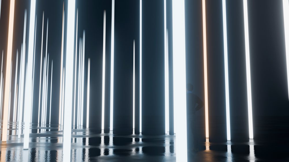 Person standing among glowing vertical light pillars in dark room