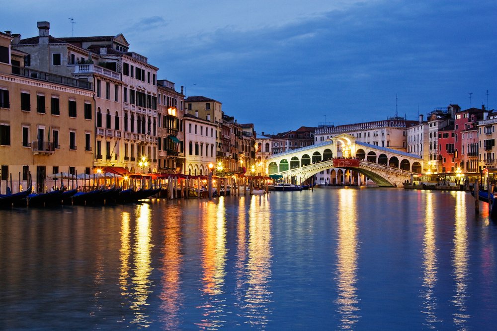 Rialto bridge over grand canal with gondolas italy evening