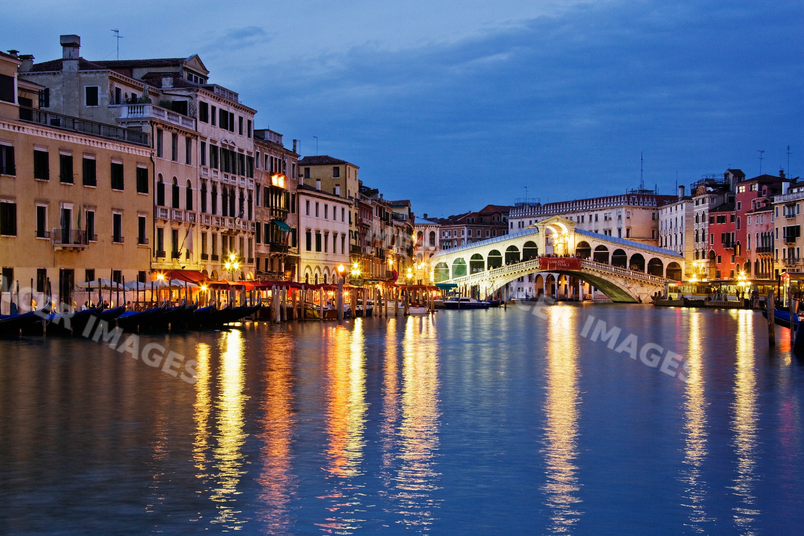 Rialto bridge over grand canal with gondolas italy evening