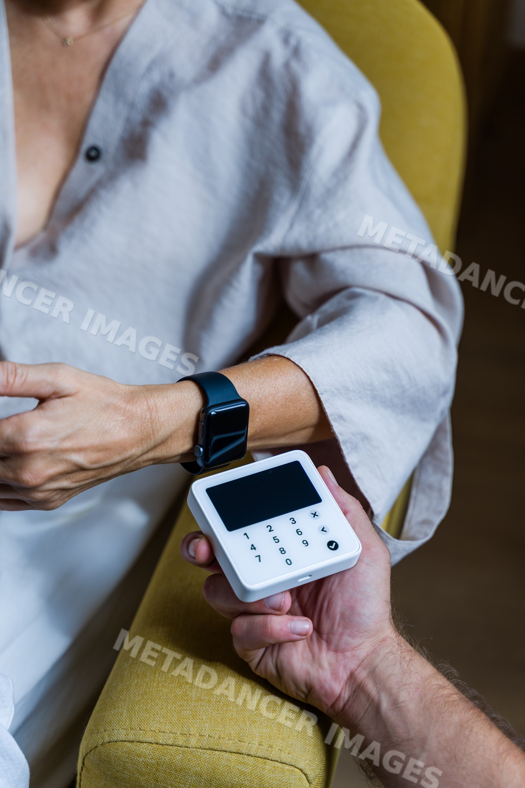 Person using smartwatch for contactless payment on white terminal