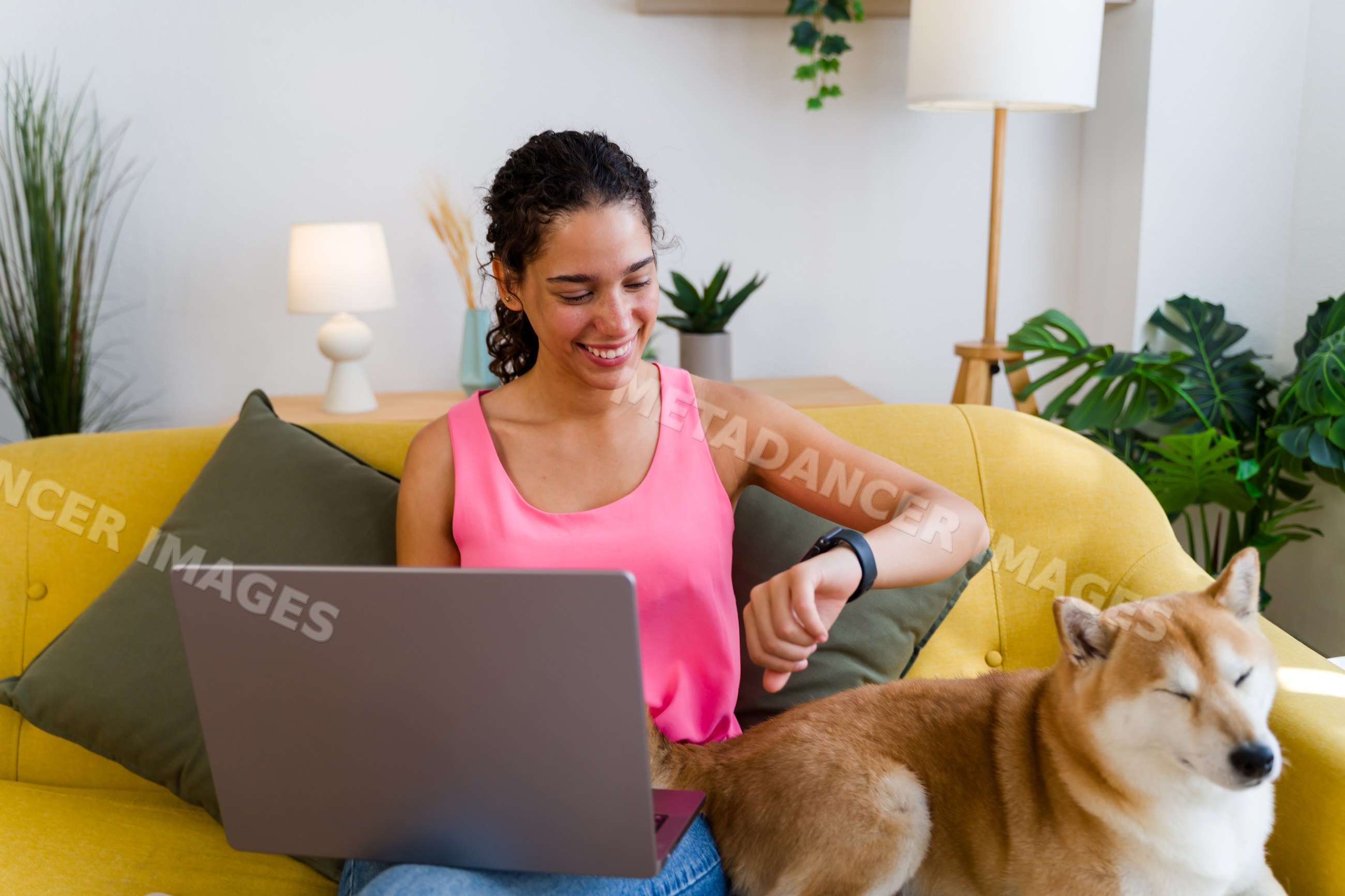 A Hispanic woman checks her smartwatch