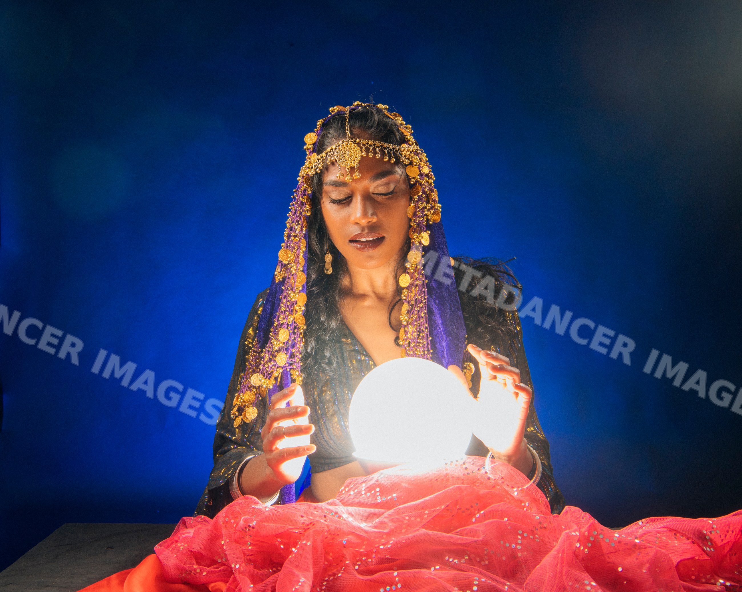 A fortune teller looks into a glowing crystal ball with mystic focus