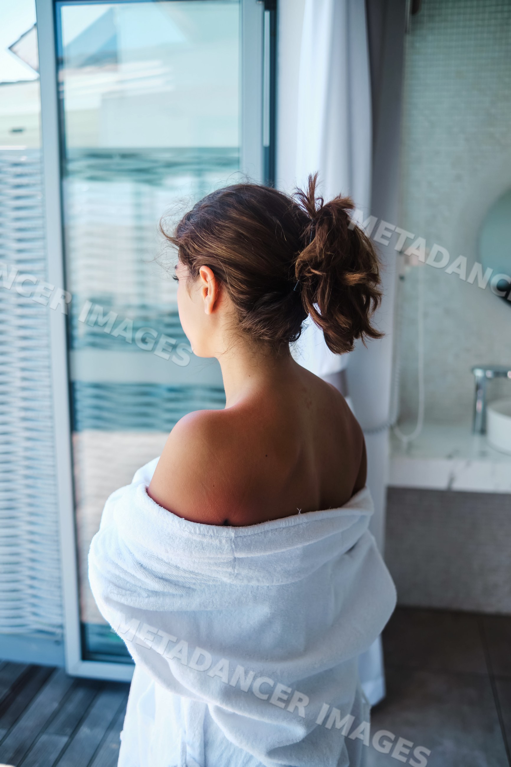 Woman in white bathrobe displaying sunburn in a Maldives hotel room