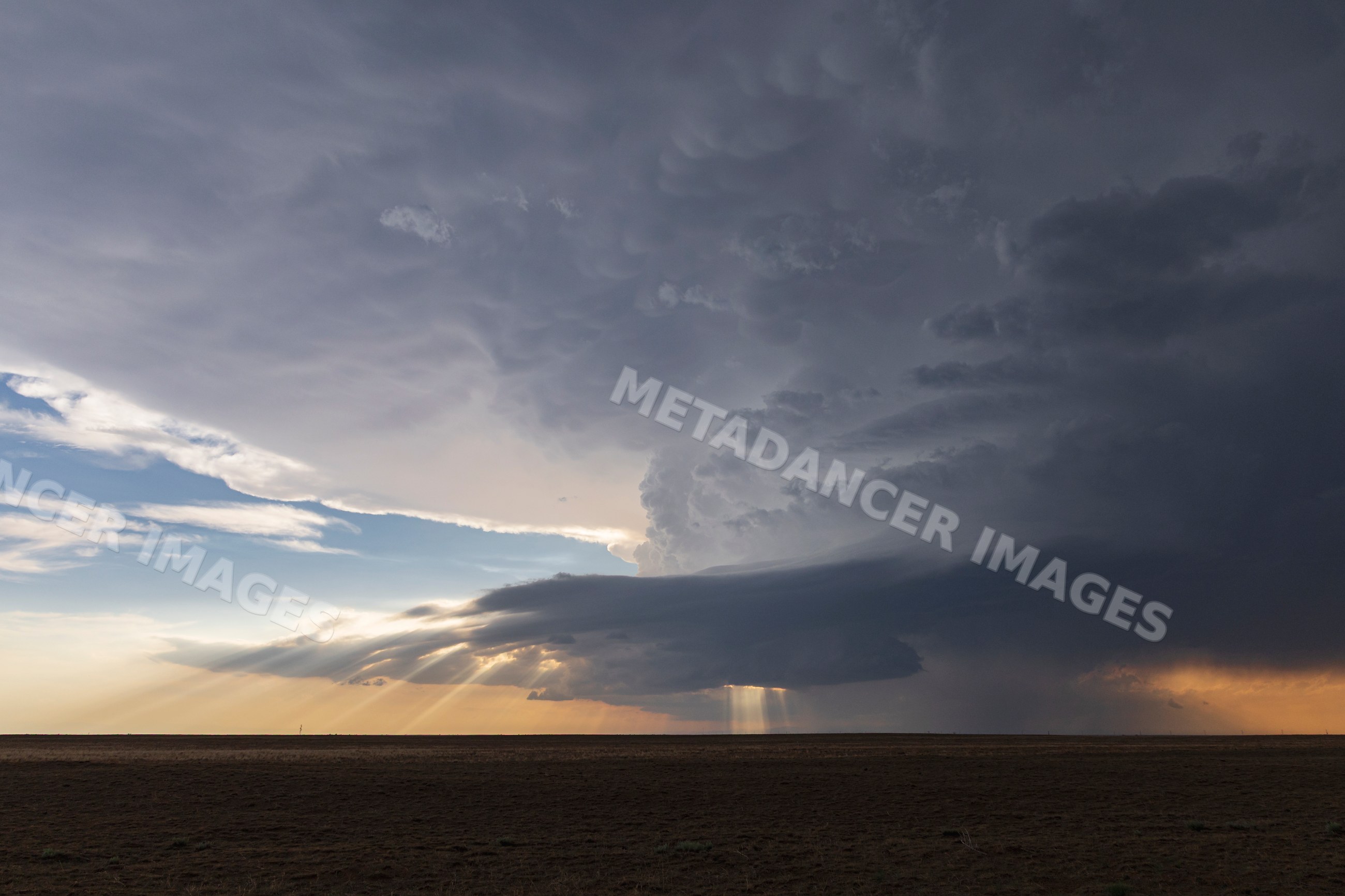 Developing Storm with sunlight rays over open plain