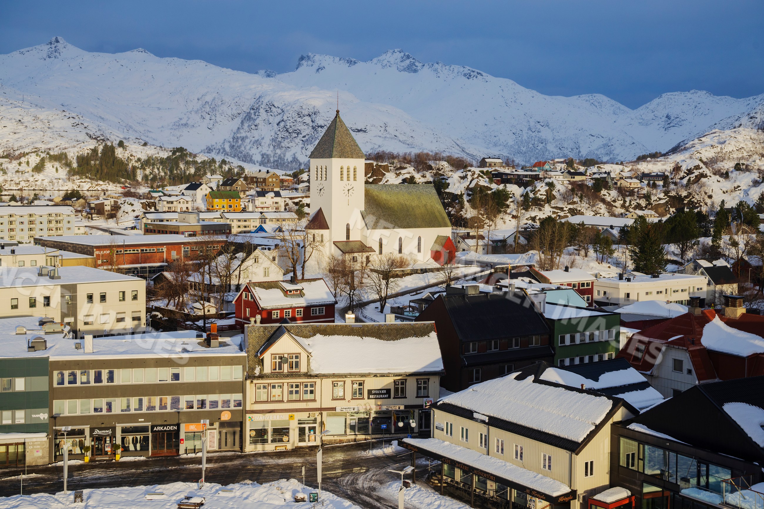 Snow-covered town of svolvaer with church and mountains in a church