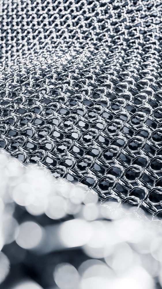 Close-up of interlocking shiny metal rings forming mesh pattern