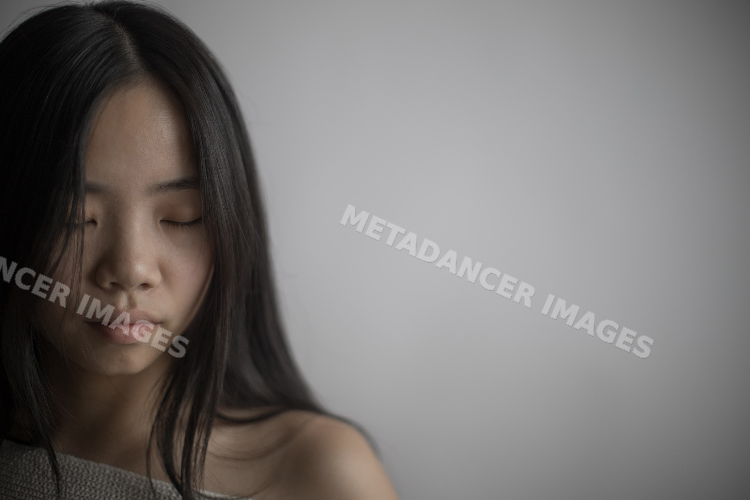 Portrait of a Southeast Asian woman with closed eyes and black hair
