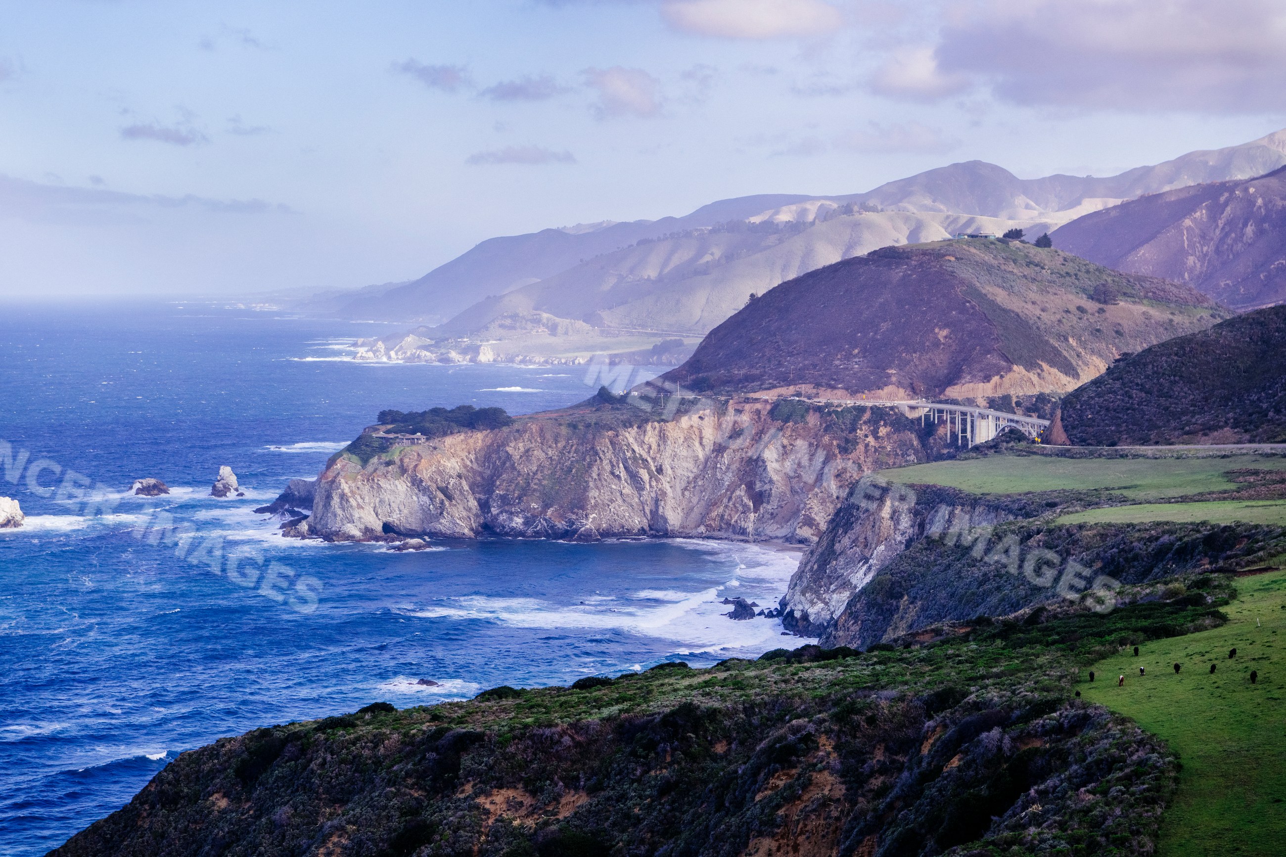 Bixby Bridge spans rugged California coastal canyon with ocean waves