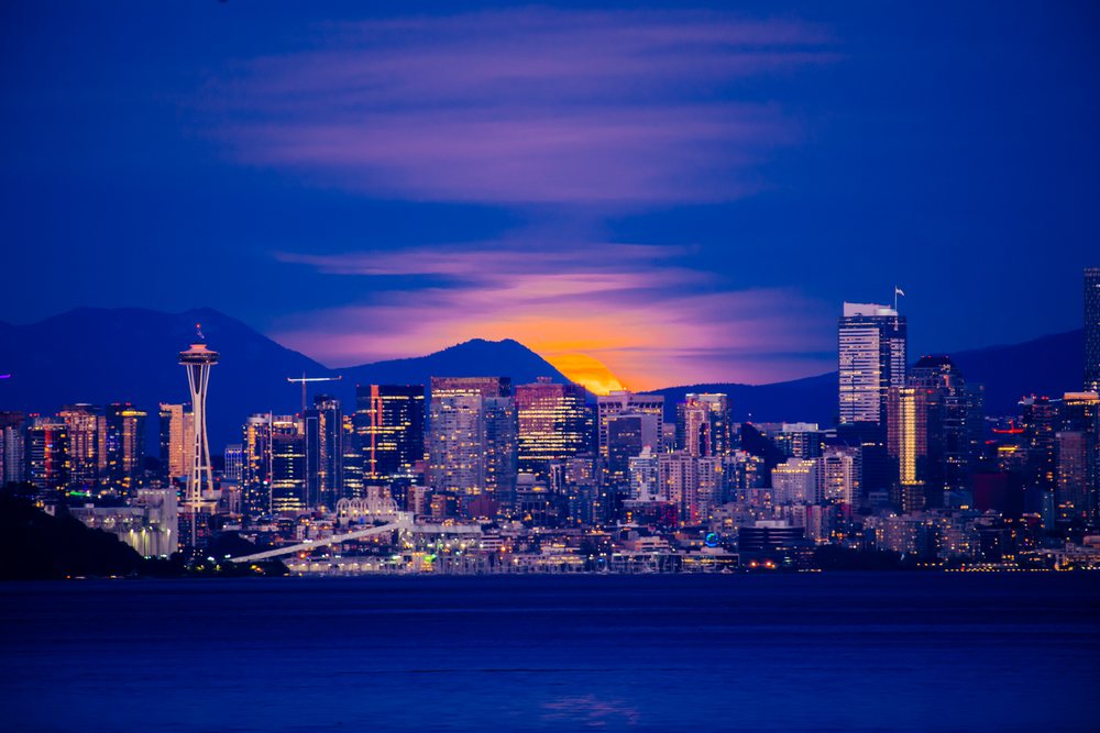 Seattle city skyline at sunset with space needle and mountains