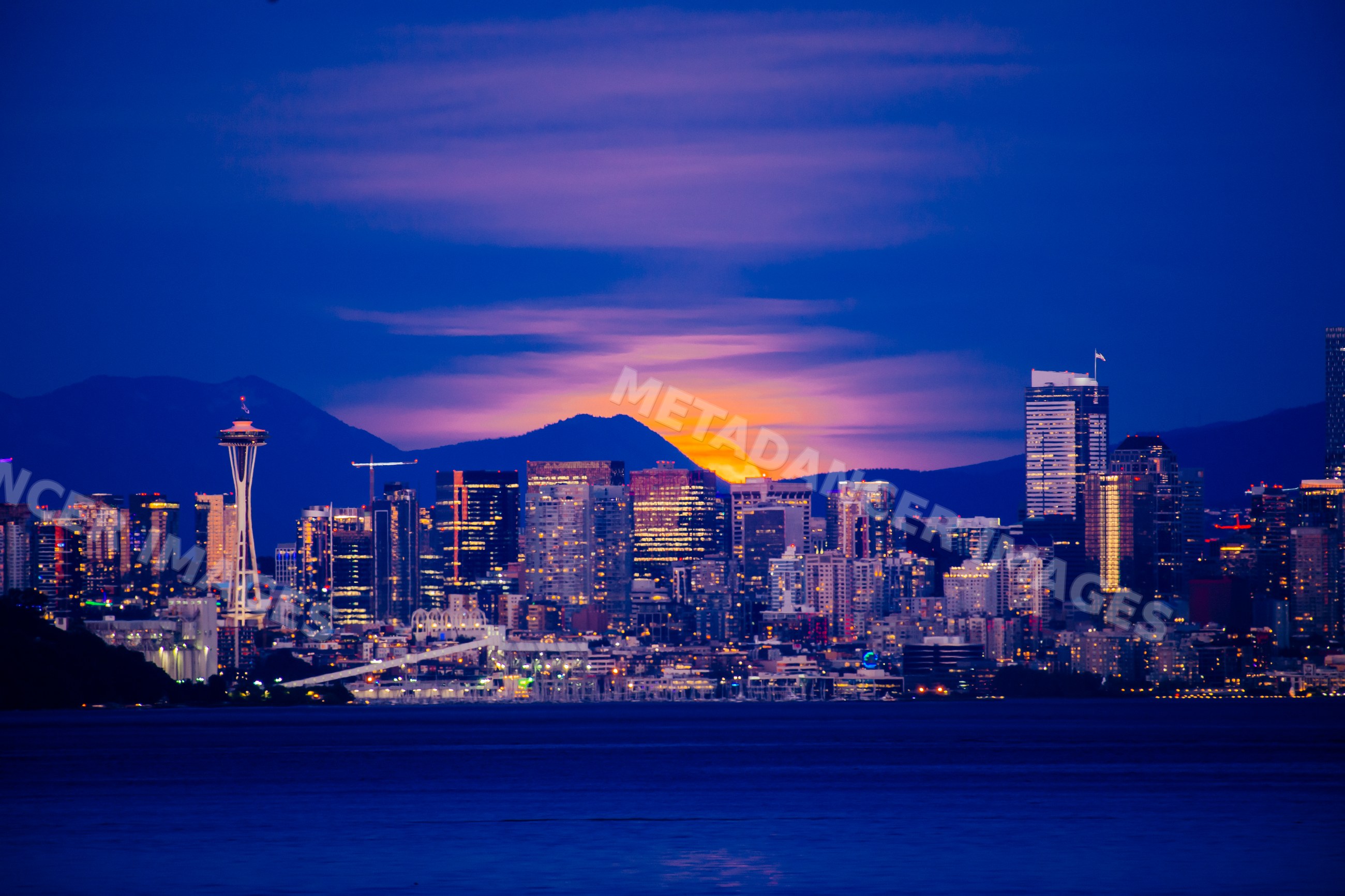 Seattle city skyline at sunset with space needle and mountains