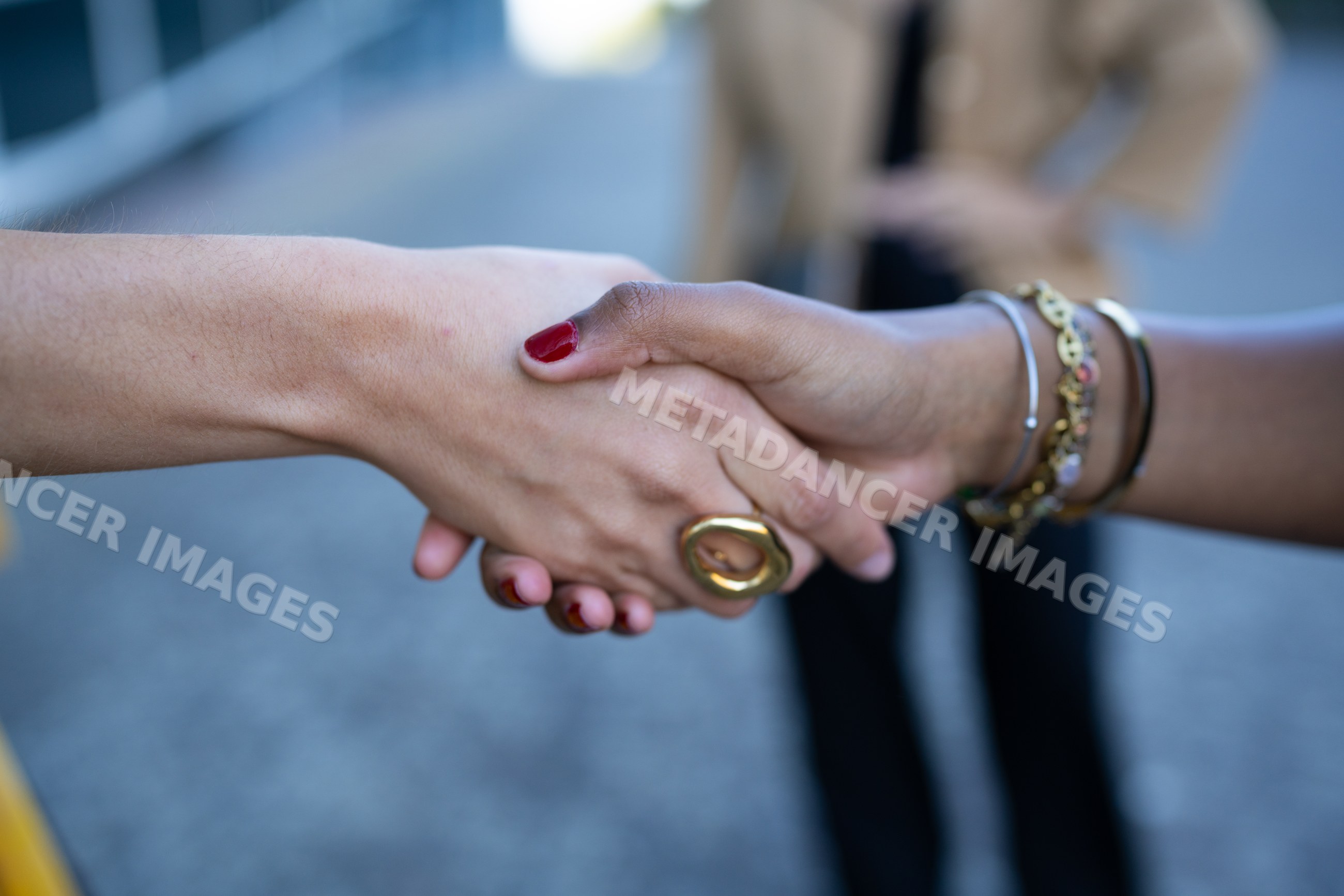 Two African American and white people shaking hands outdoors