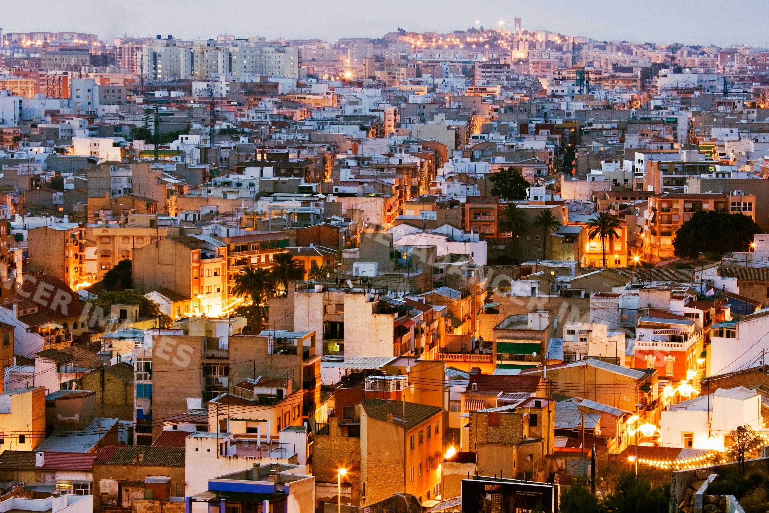 Cityscape of residential buildings lit up at dusk, Spain