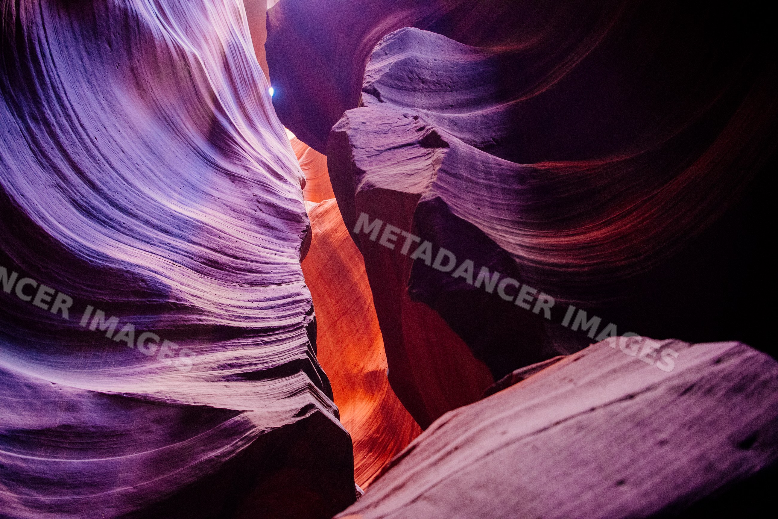 Sunlight illuminates sculpted sandstone walls inside antelope canyon